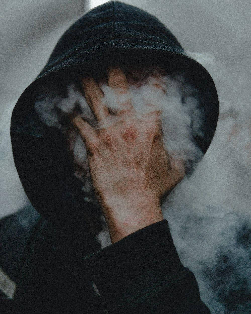 dark hoodie, hand on face, thick white vapor, SD Phone Wallpaper