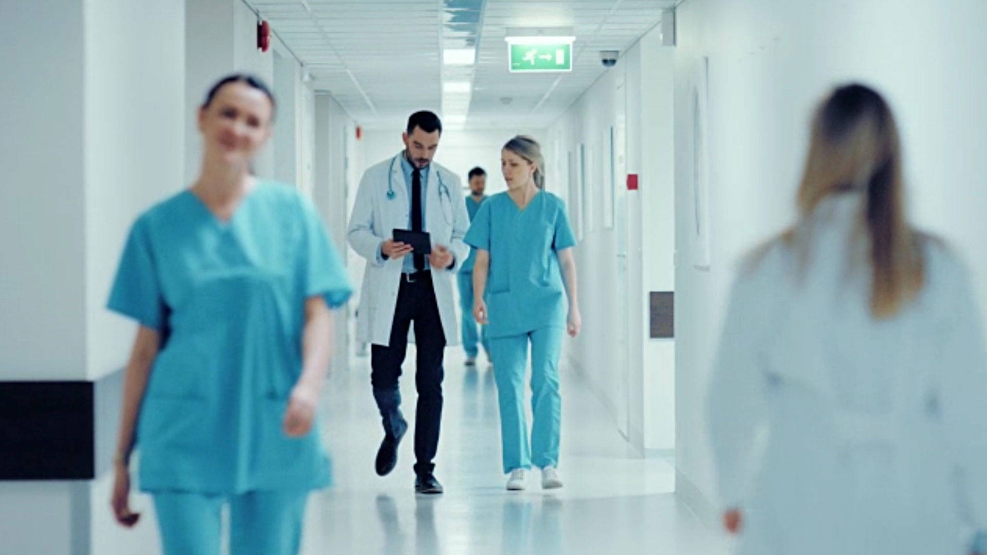 teal scrubs, bright sterile hospital corridor, doctor checking his tablet, Full HD Desktop Wallpaper