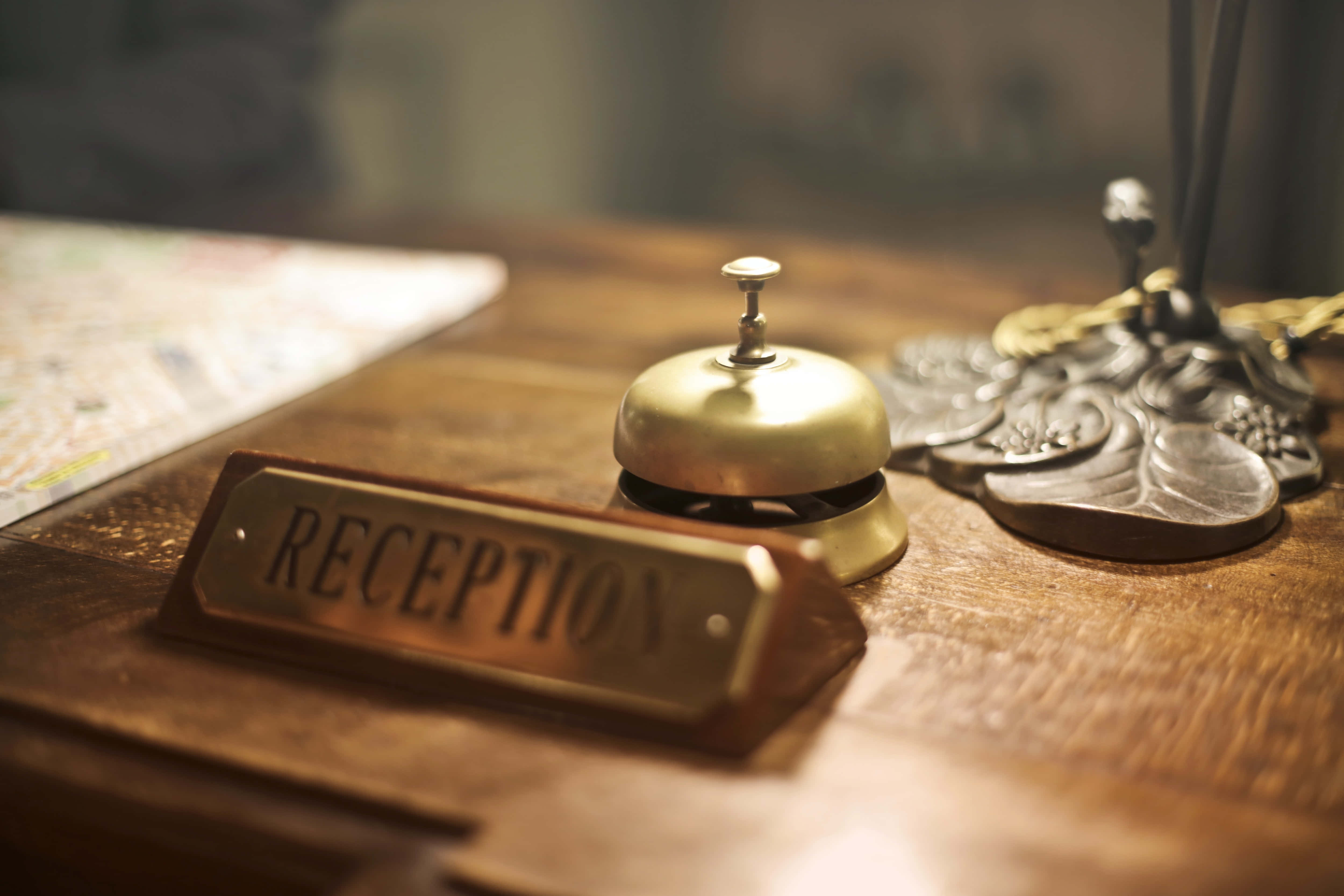 hospitality 5000, vintage brass reception bell, warm wooden desk, 4K Desktop Wallpaper