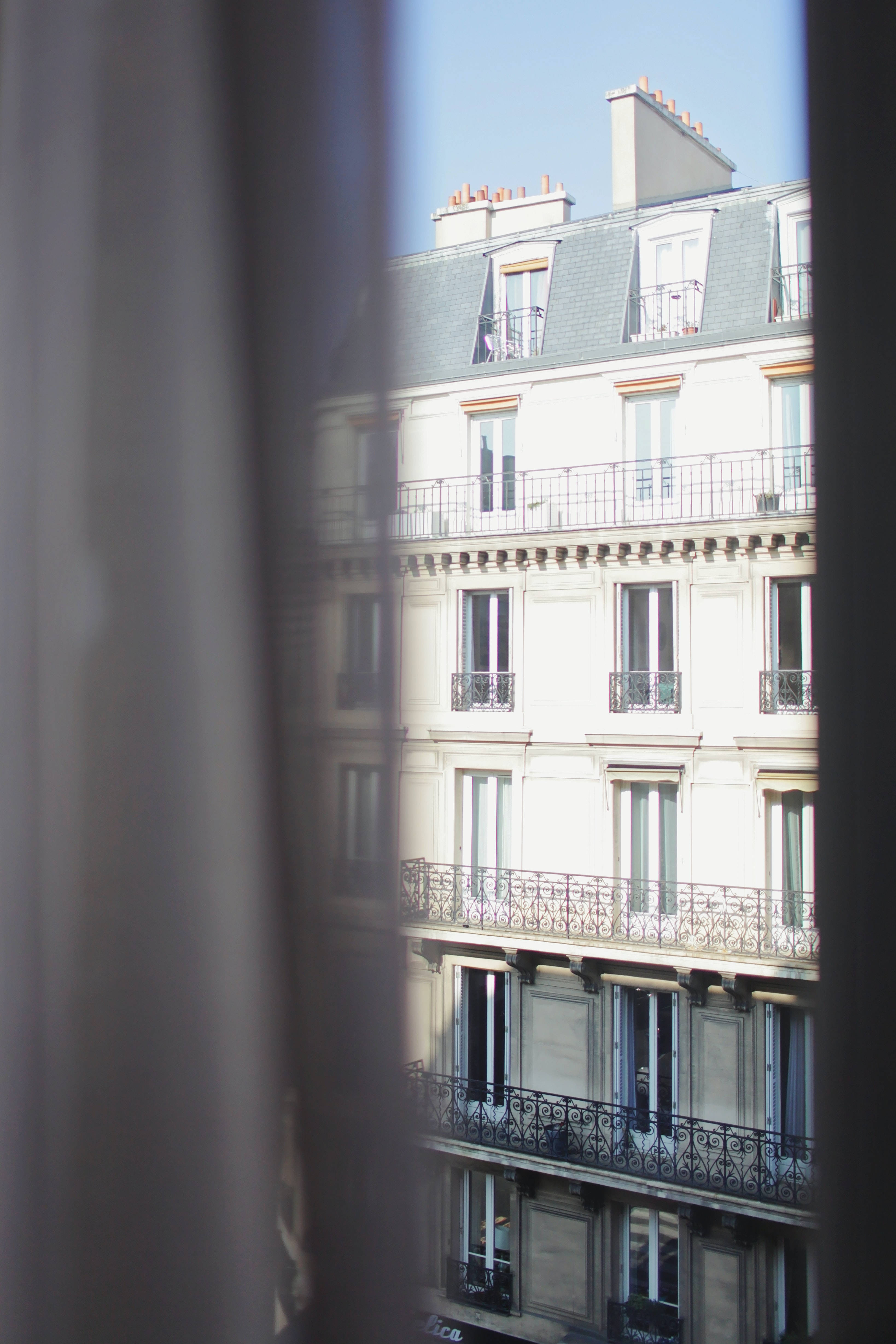 Parisian apartment building, sheer curtains, bright sunny day, 4K Phone Wallpaper