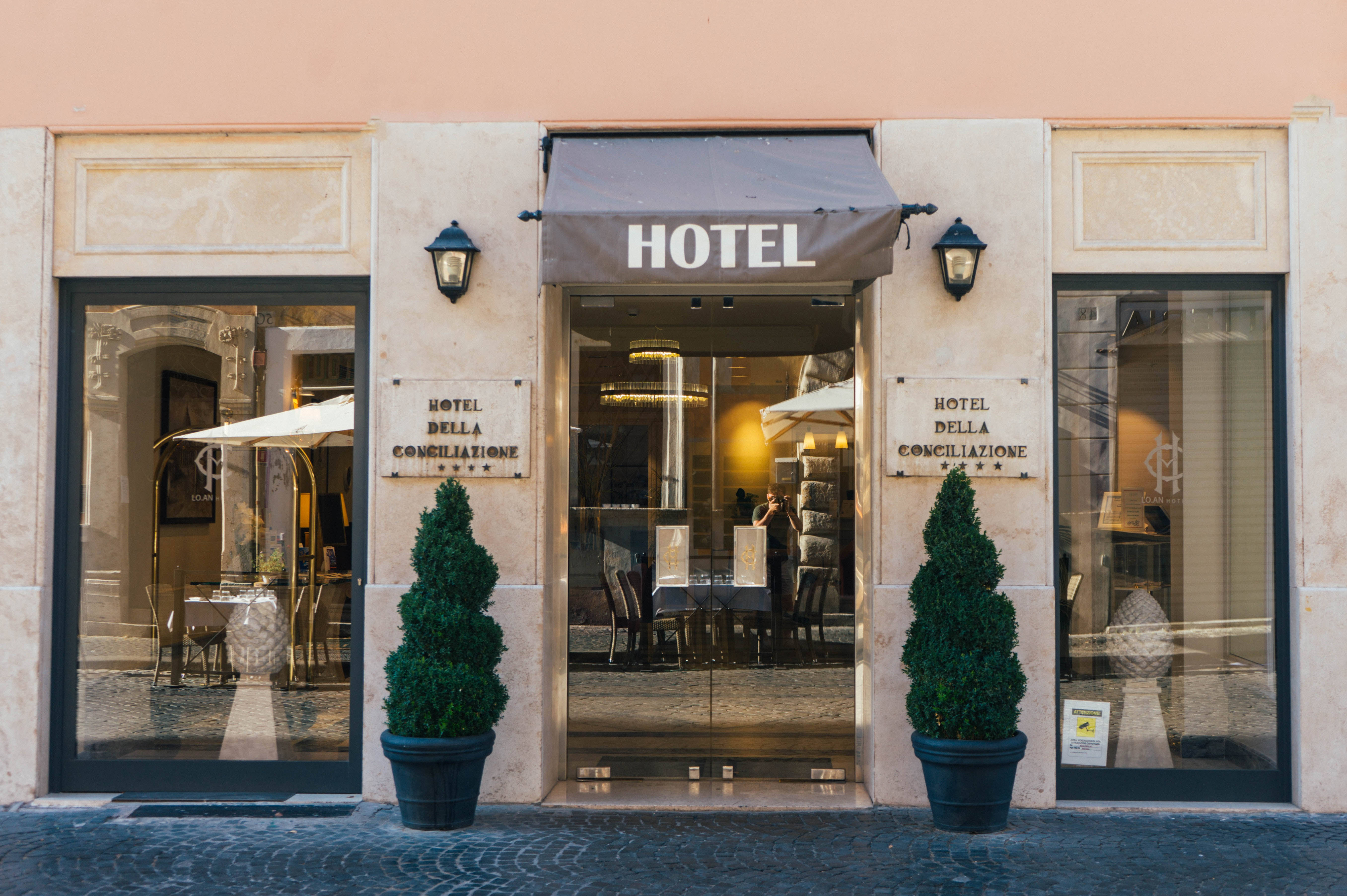 peach-colored facade, glass doors, potted evergreens, 5K Desktop Wallpaper