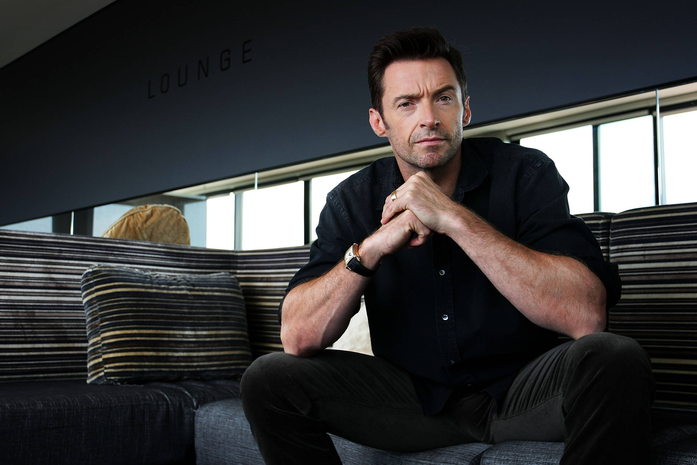 Hugh Jackman, black shirt, striped couch, 2K Desktop Wallpaper
