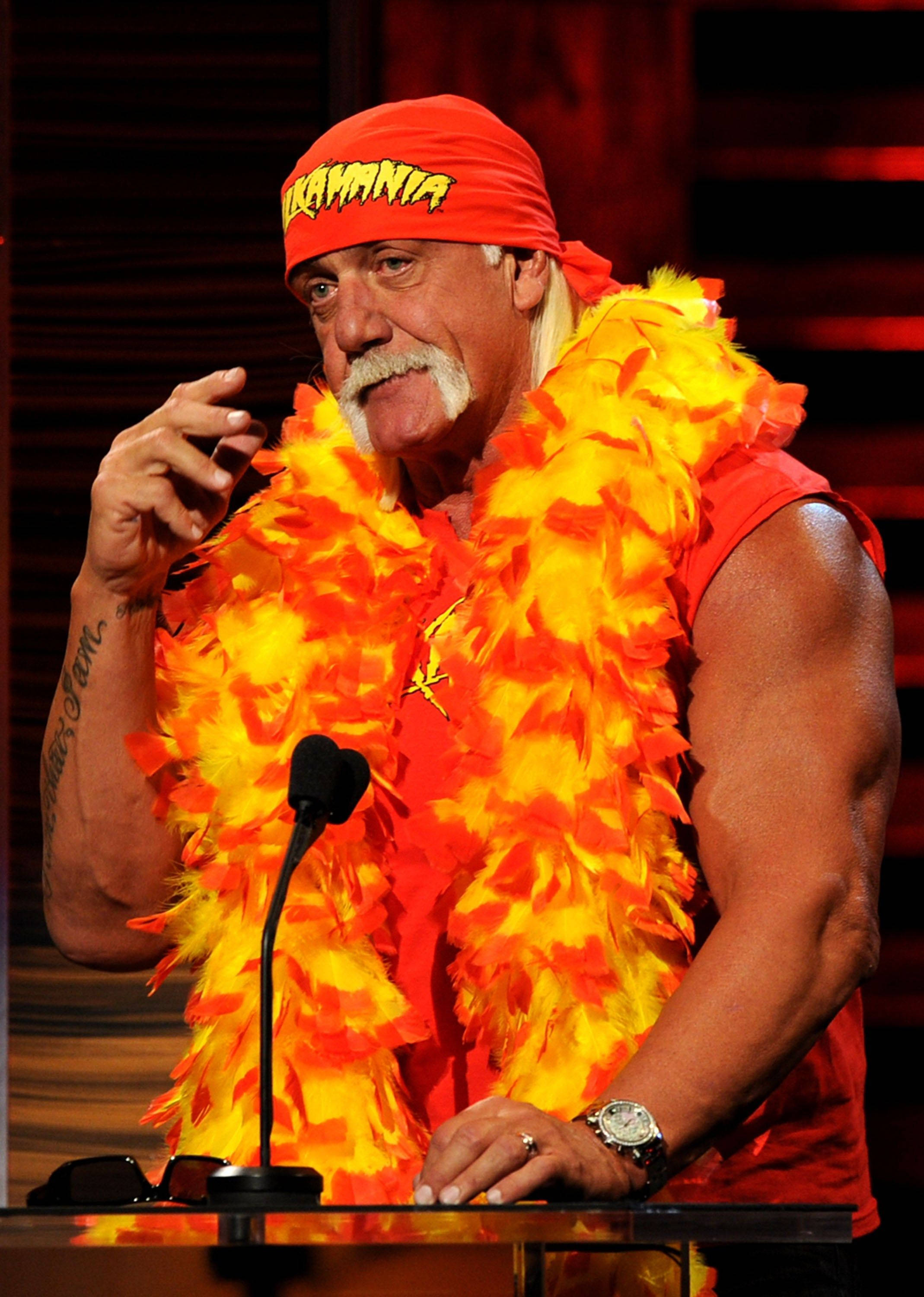 Hulk Hogan, orange and yellow feathered attire, podium, 2K Phone Wallpaper