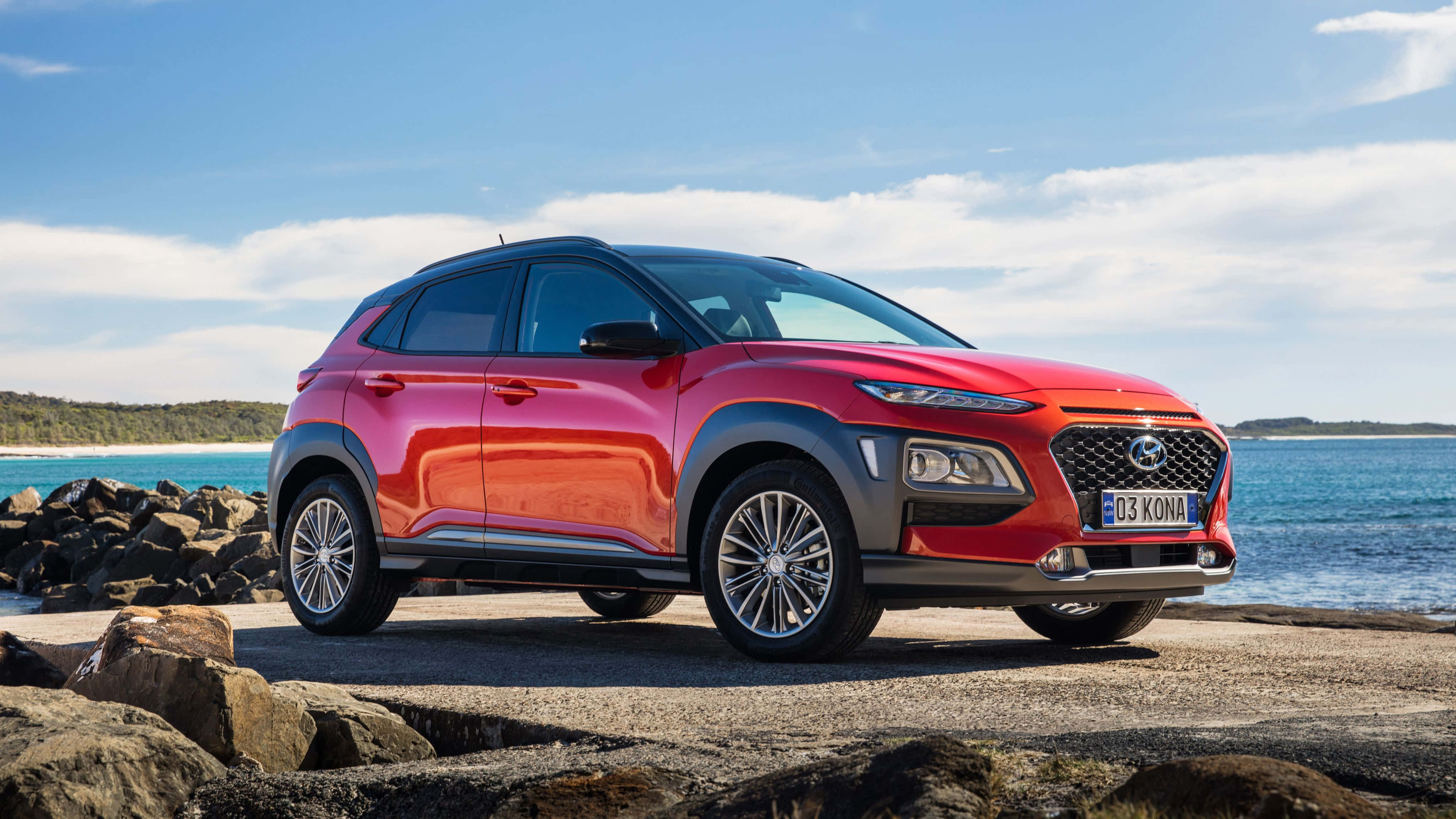 Hyundai Kona, vibrant red, rocky coastal road, 4K Desktop Wallpaper