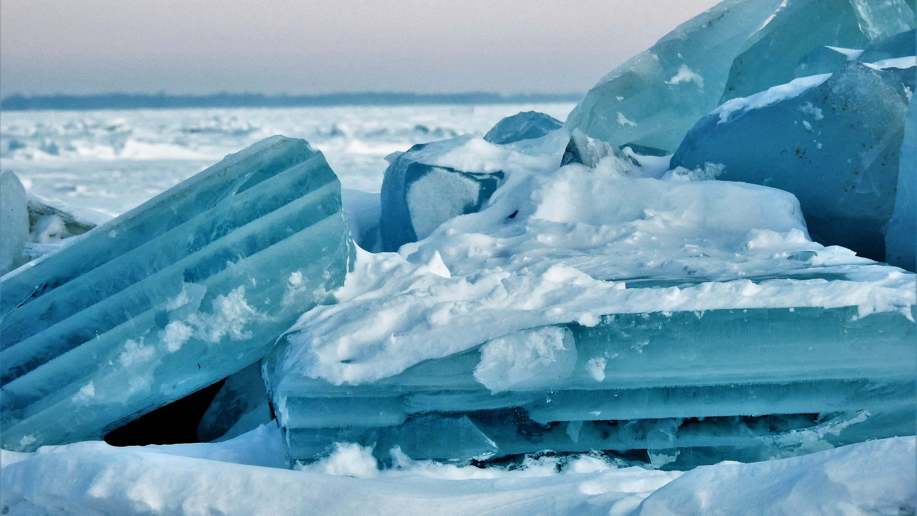 Ice Blue, translucent blue ice blocks, snow-covered ground, 2K Desktop Wallpaper