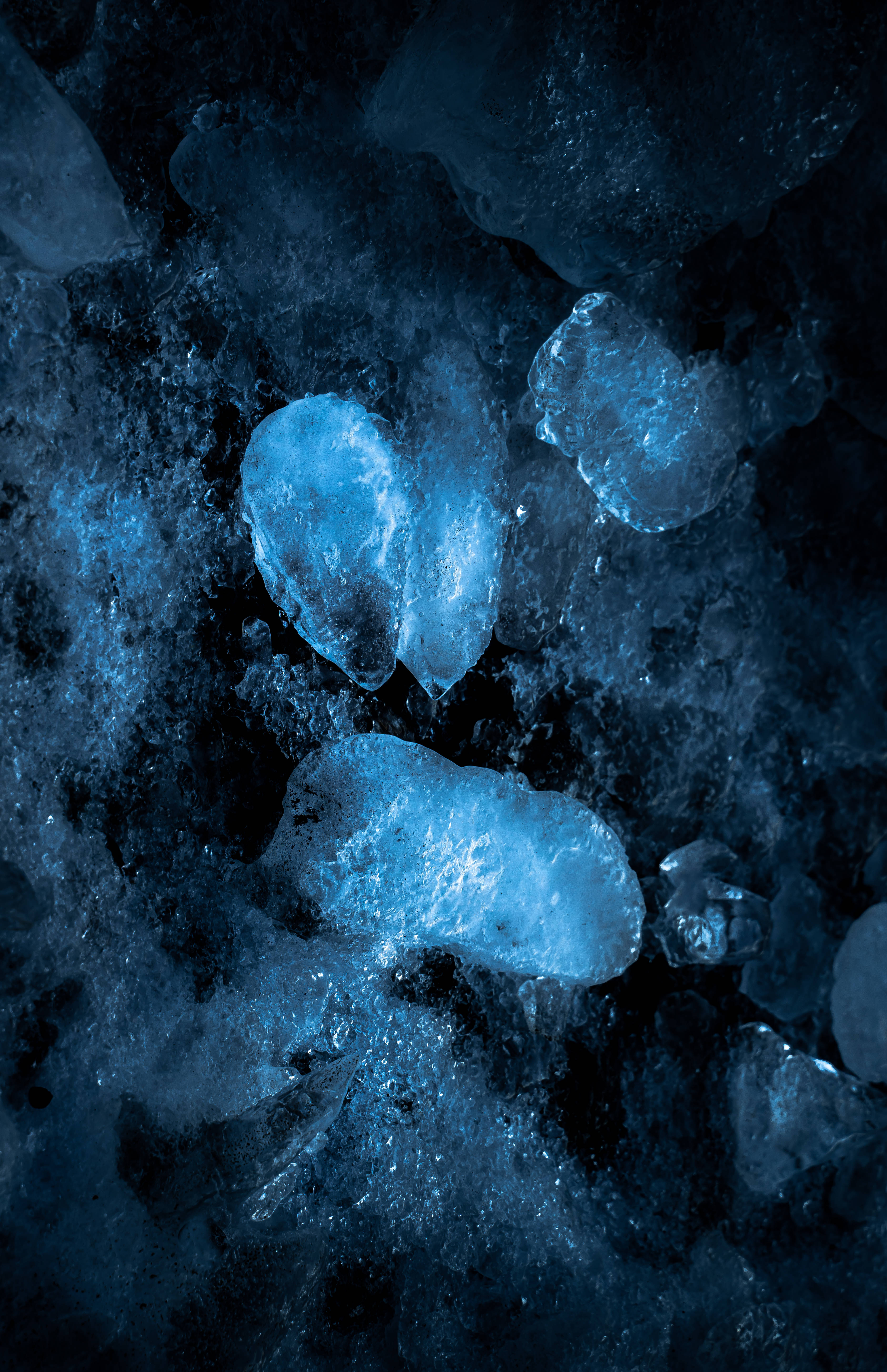Blue Ice Aesthetic Phone, glowing translucent blue ice chunks, deep shadowy water, 5K Phone Wallpaper