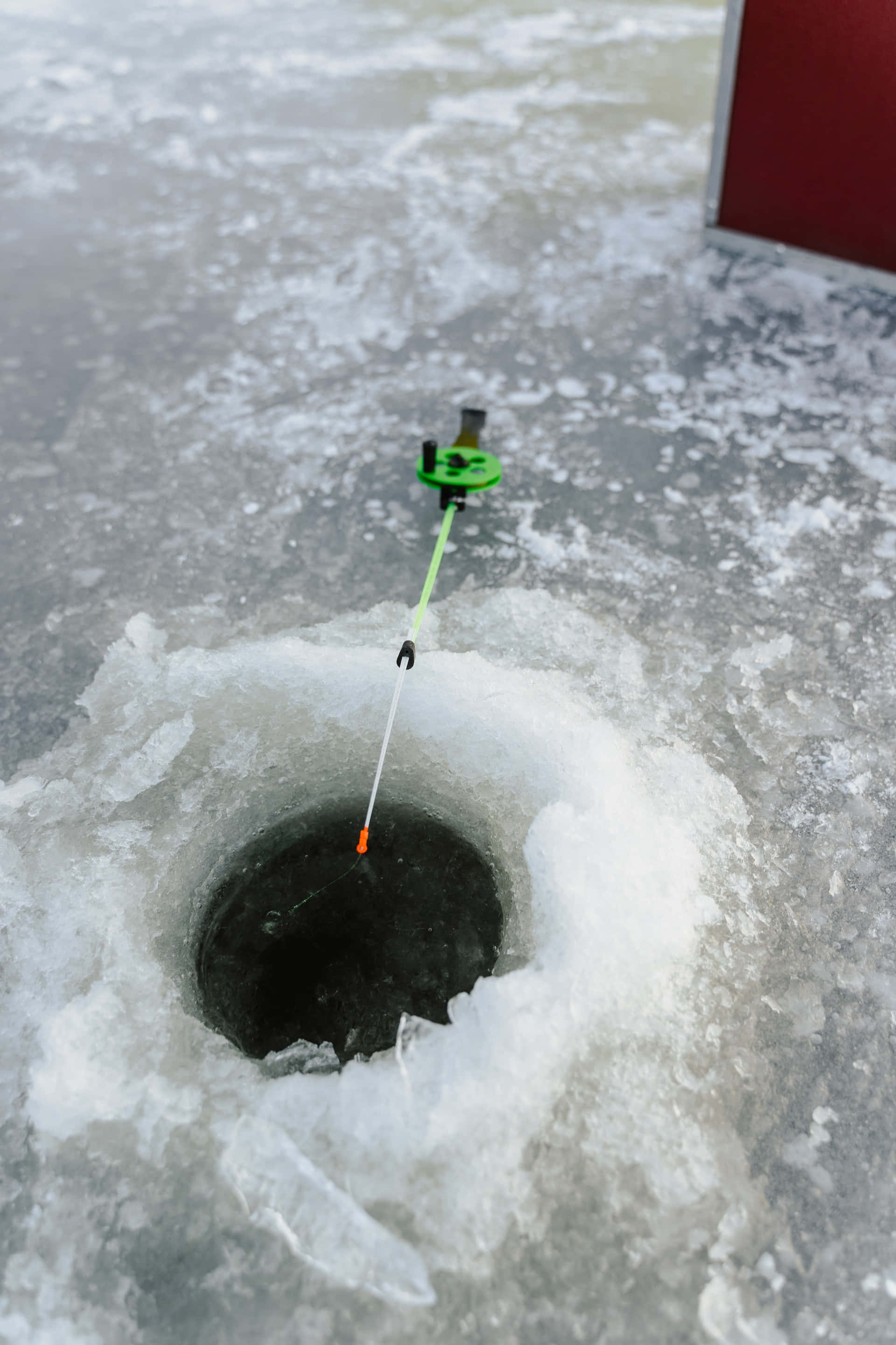 bright green fishing float, dark ice hole, snowy frozen lake, 2K Phone Wallpaper