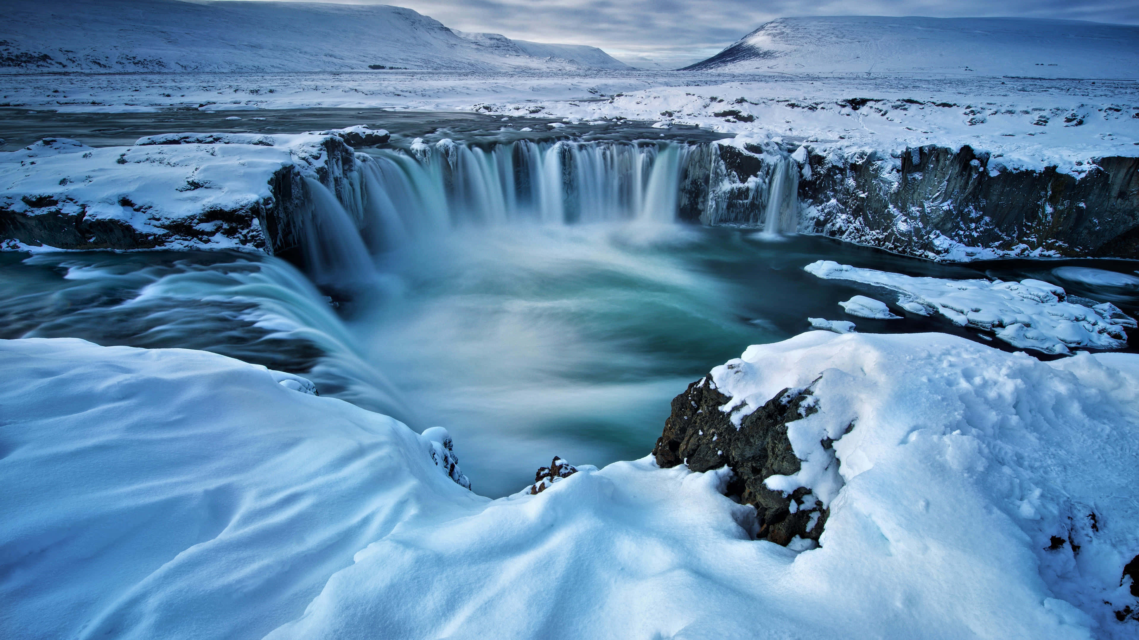 Iceland, winter waterfall, snow-covered cliffs, 4K Desktop Wallpaper