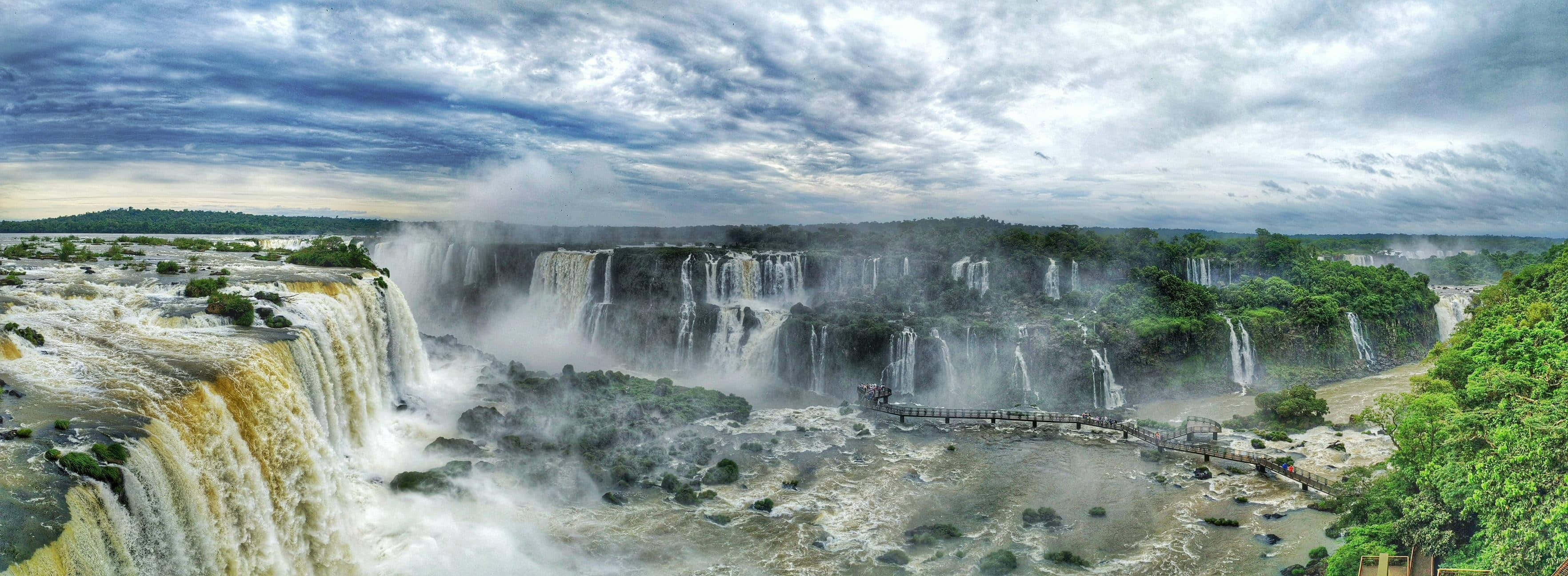 Iguazu Falls, blue sky, cascading water mist, 2K Desktop Wallpaper