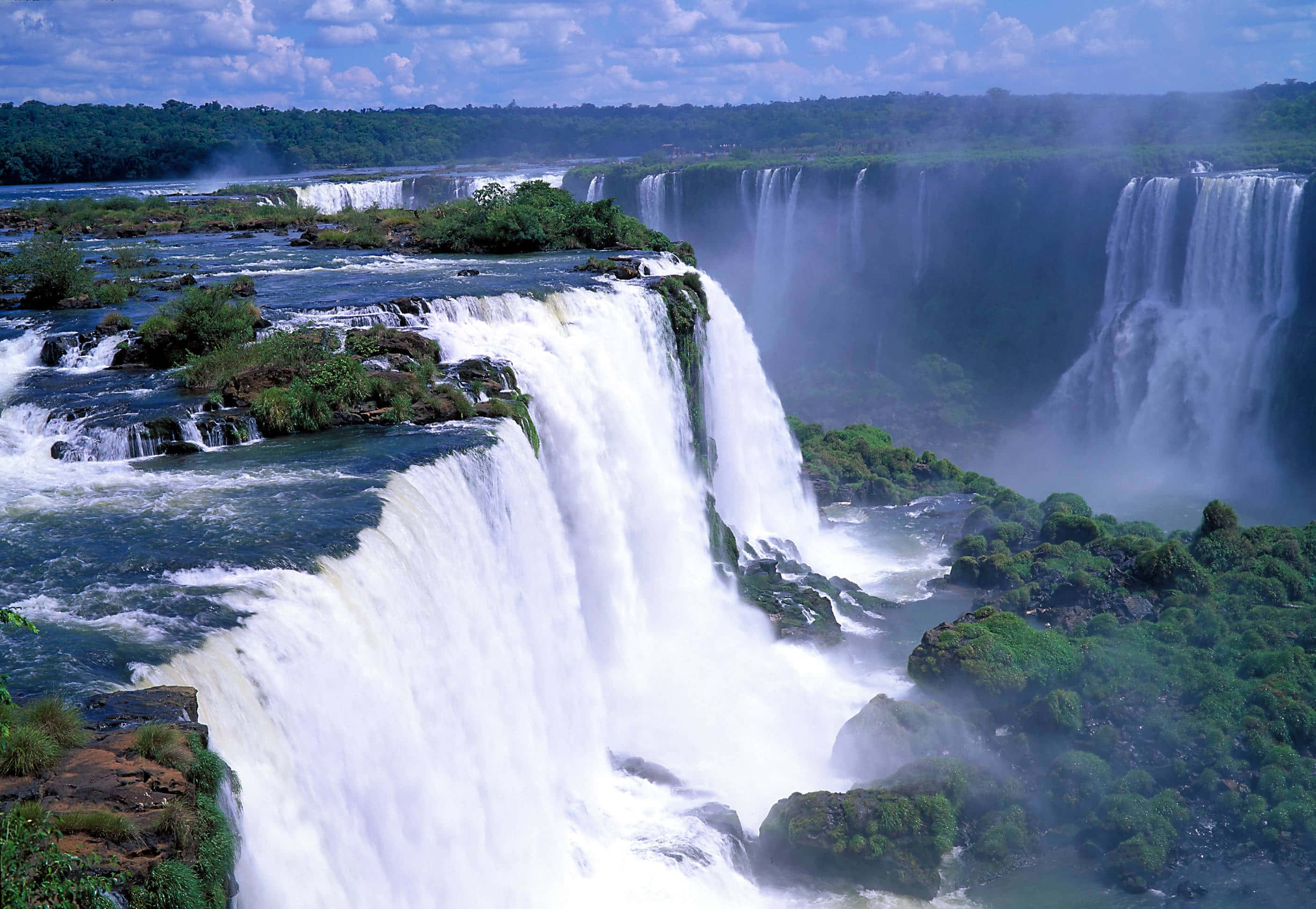 Iguazu Falls, lush green cliffs, bright blue sky, 2K Desktop Wallpaper