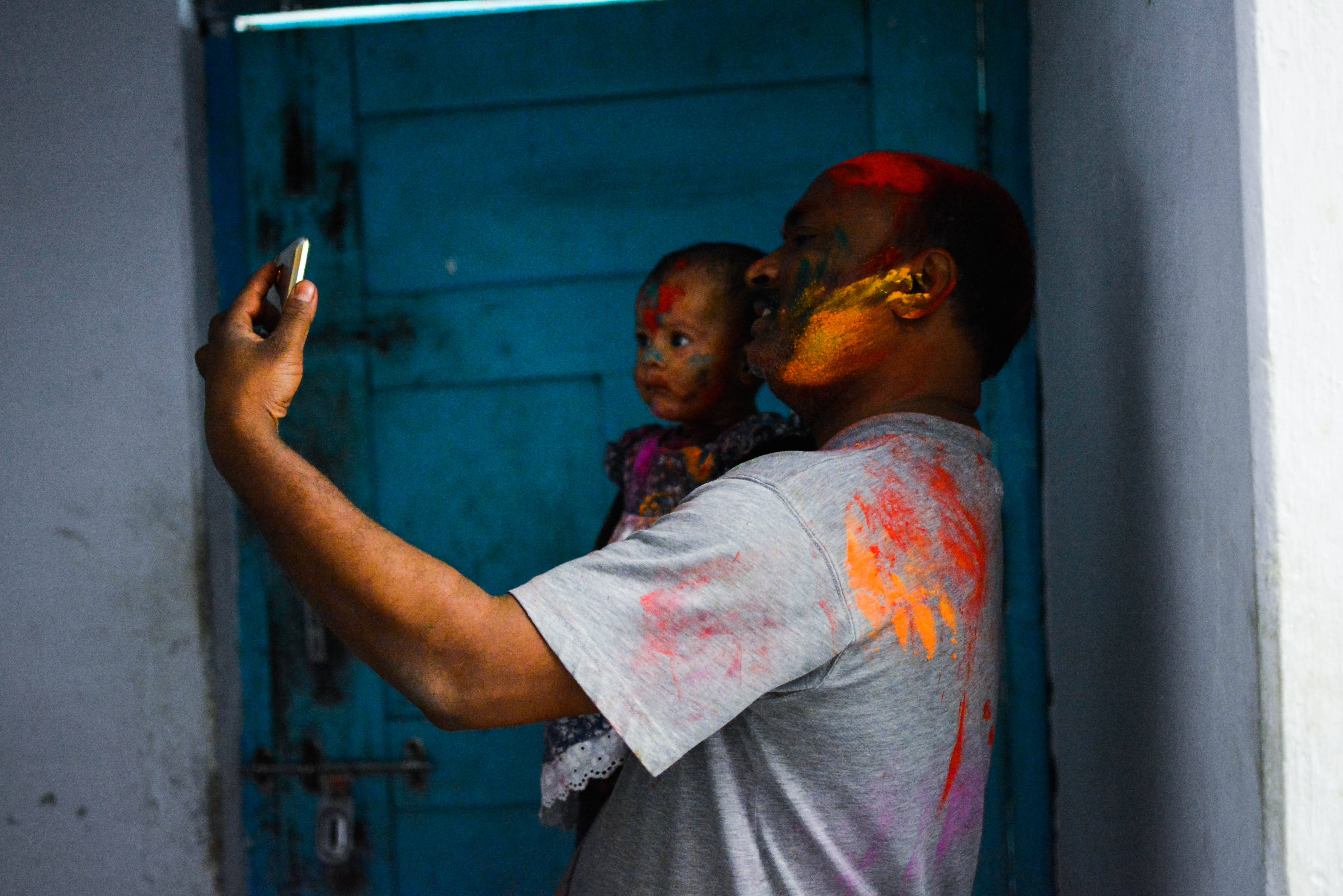 India Holi, vibrant powders, weathered blue door, 4K Desktop Wallpaper