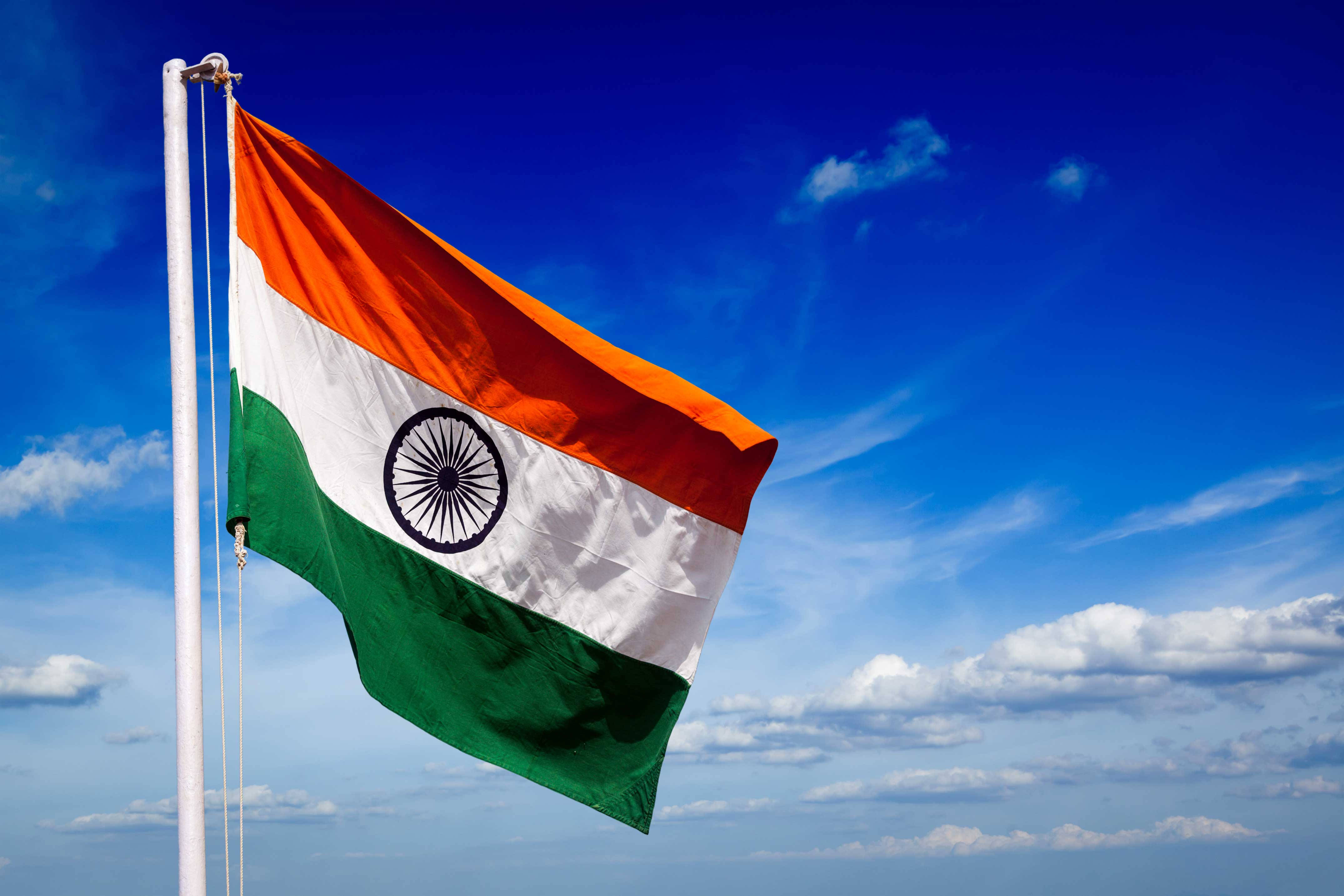 Indian flag, vibrant blue sky, scattered white clouds, 4K Desktop Wallpaper