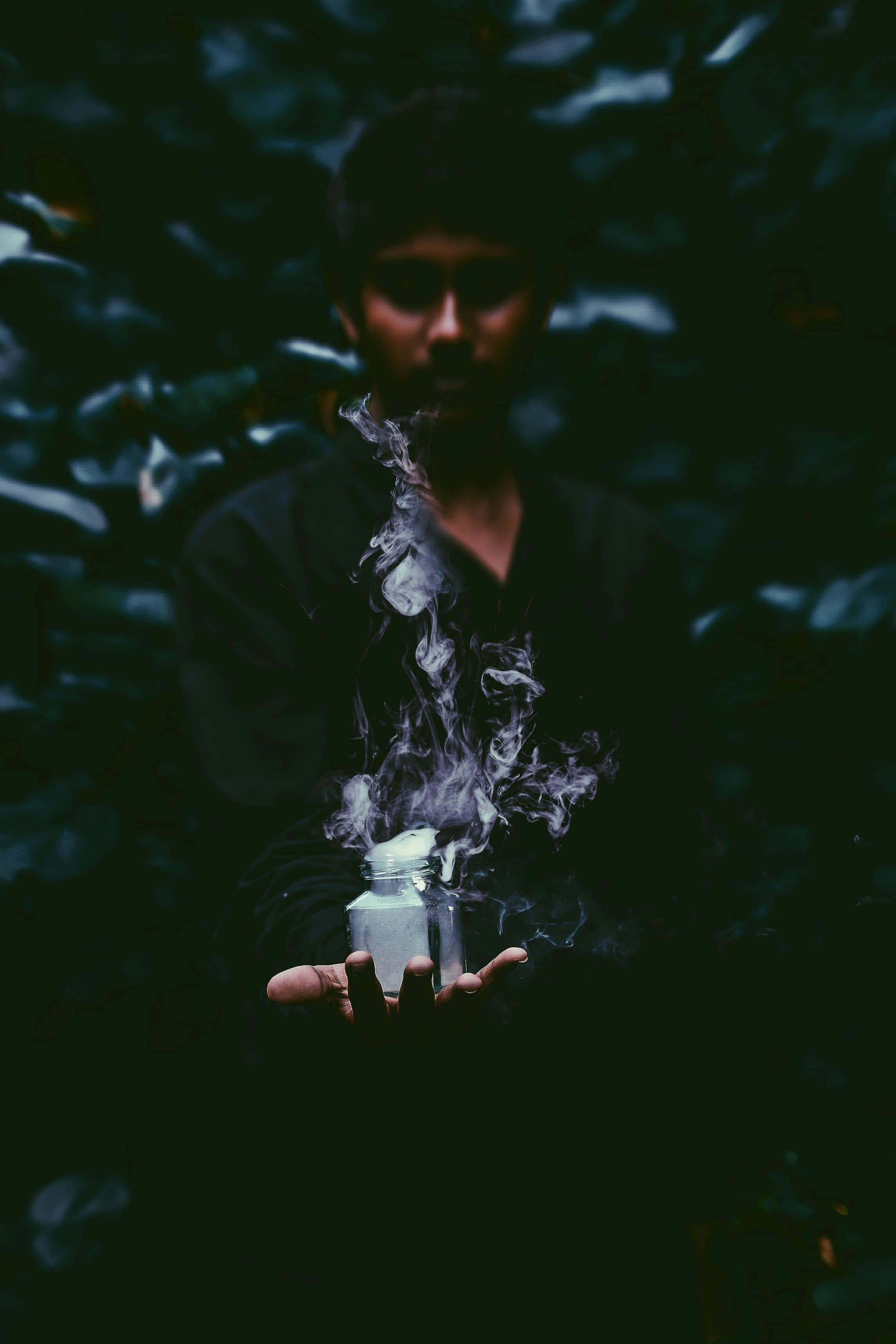 Indian Guy, steaming jar, dark foliage, 2K Phone Wallpaper