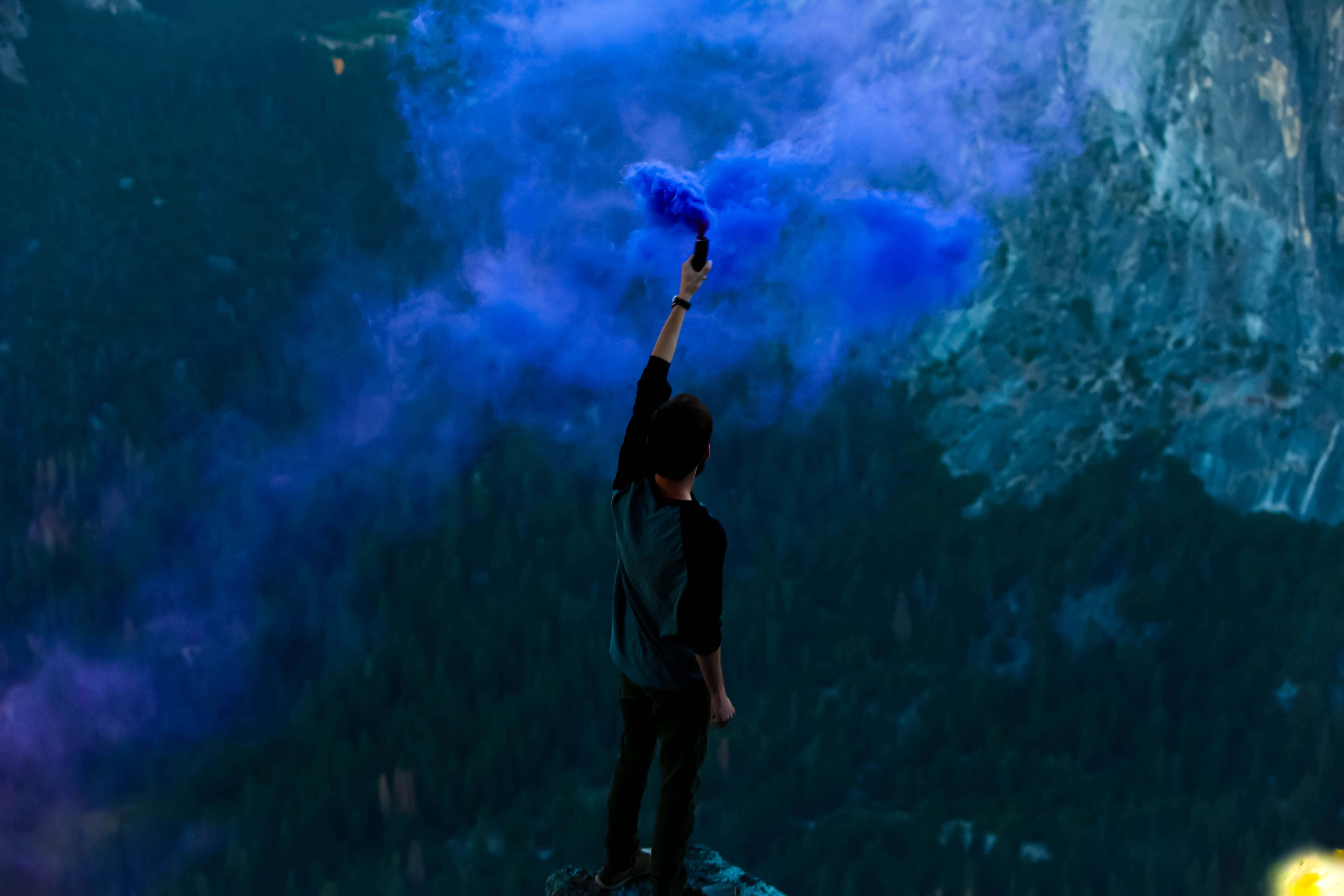 Indigo, vibrant blue smoke, dark mountainous backdrop, 5K Desktop Wallpaper