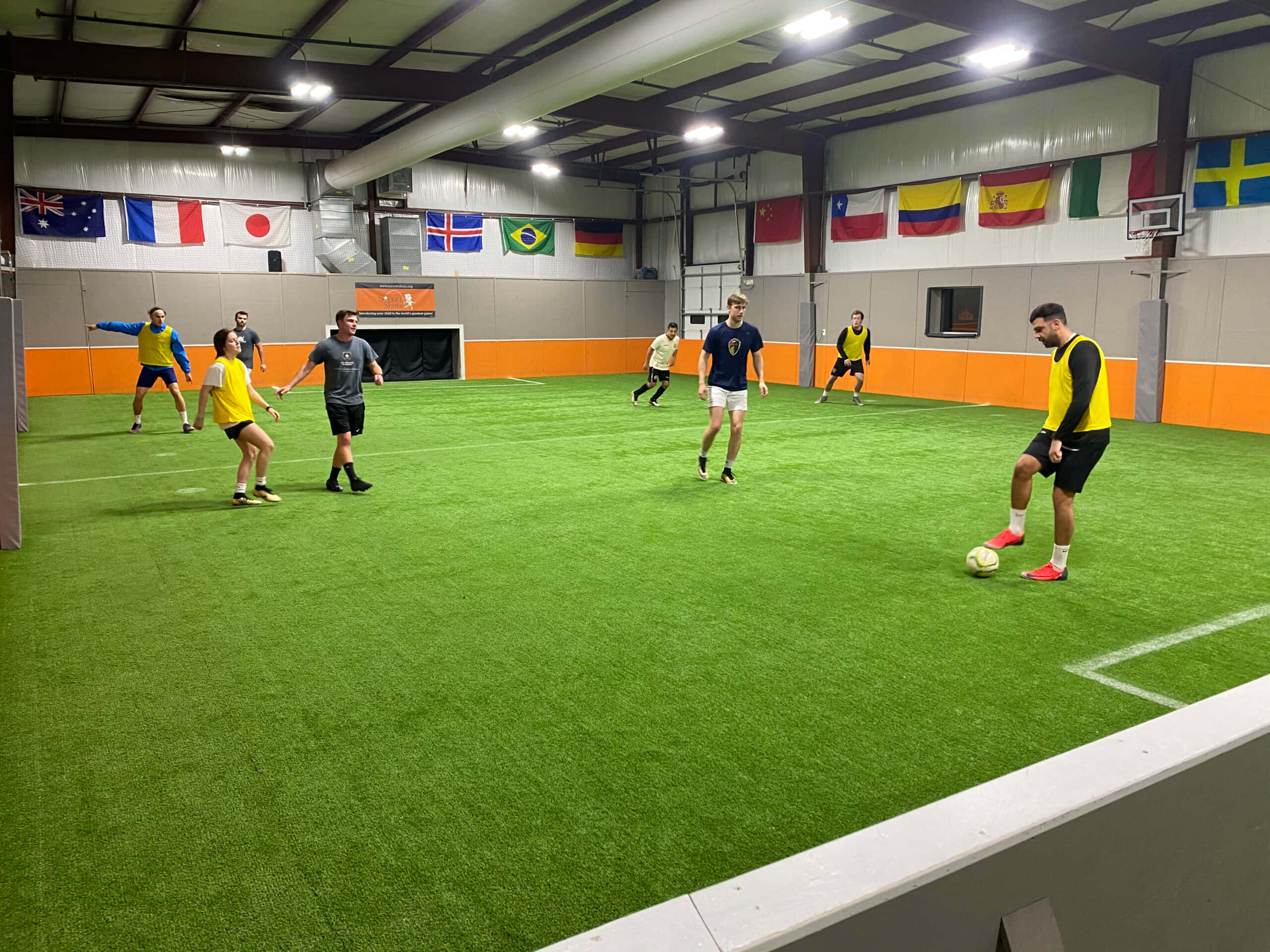 yellow and black gear, vibrant green indoor turf, bright overhead lights, 2K Desktop Wallpaper