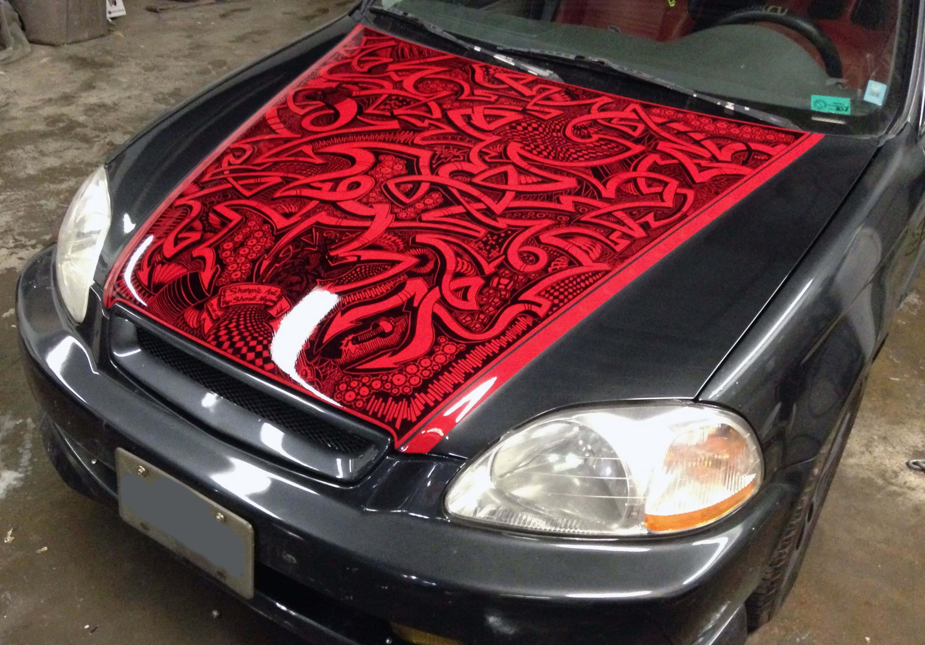 black car, red tribal-style airbrushed design, intricate swirling patterns, 2K Desktop Wallpaper