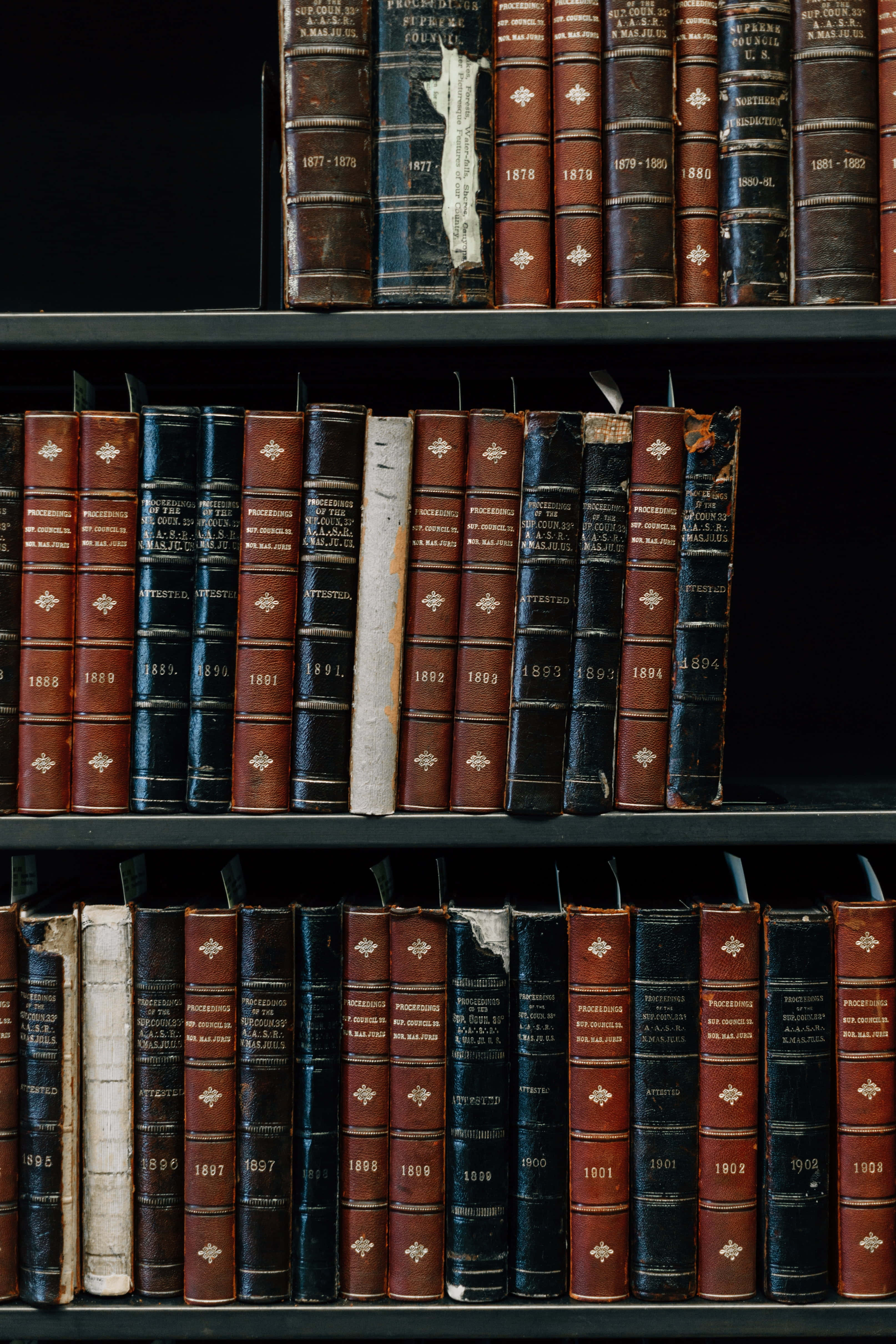 vintage leather-bound books, gold embossed titles, dark wooden shelves, 4K Phone Wallpaper