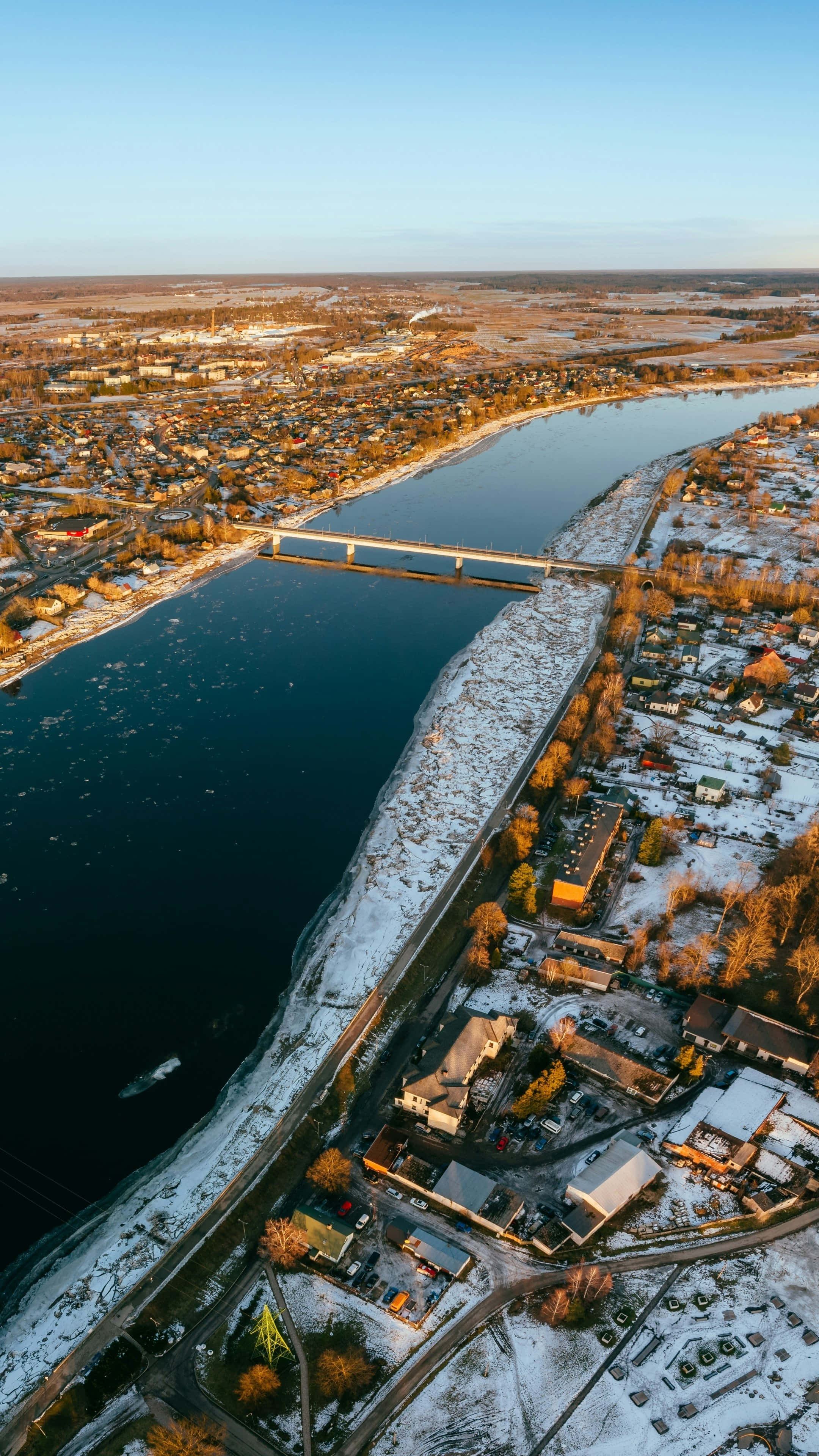 iPhone 16 Pro Max, snow covered town, wide river, 4K Phone Wallpaper