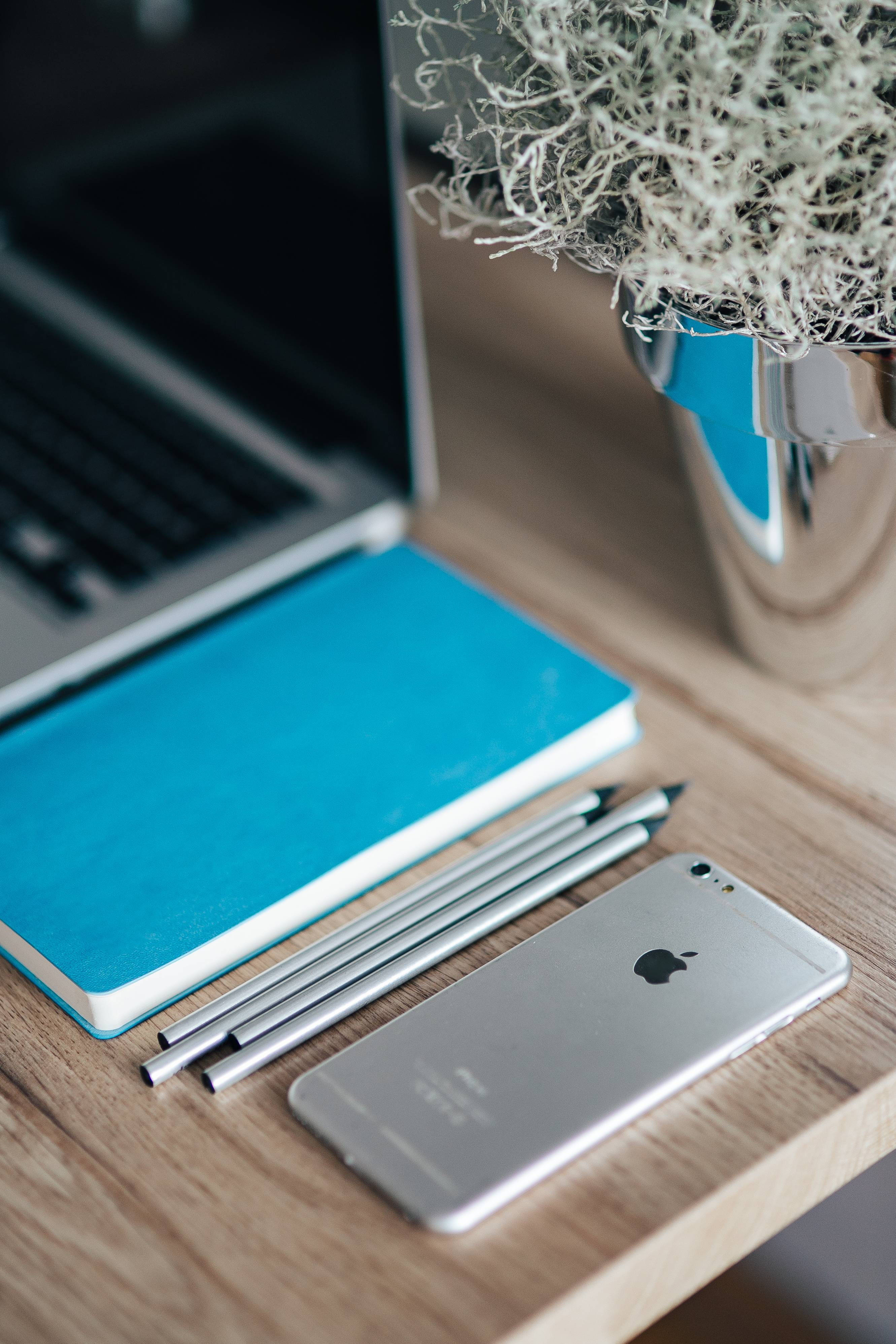 iPhone Desk, blue journal, silver laptop, 4K Phone Wallpaper