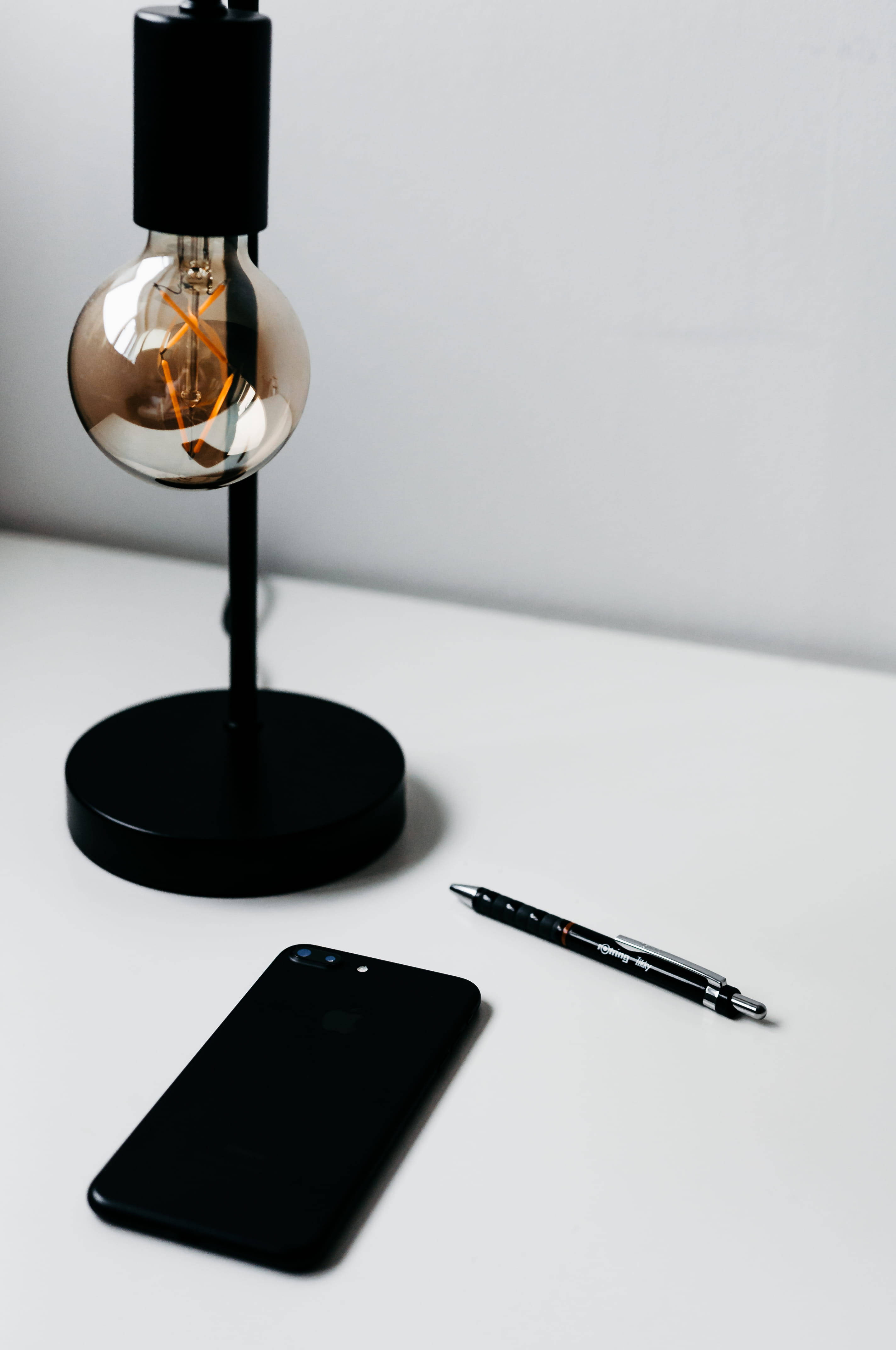 iPhone, minimalist desk, black Edison bulb lamp, 4K Phone Wallpaper