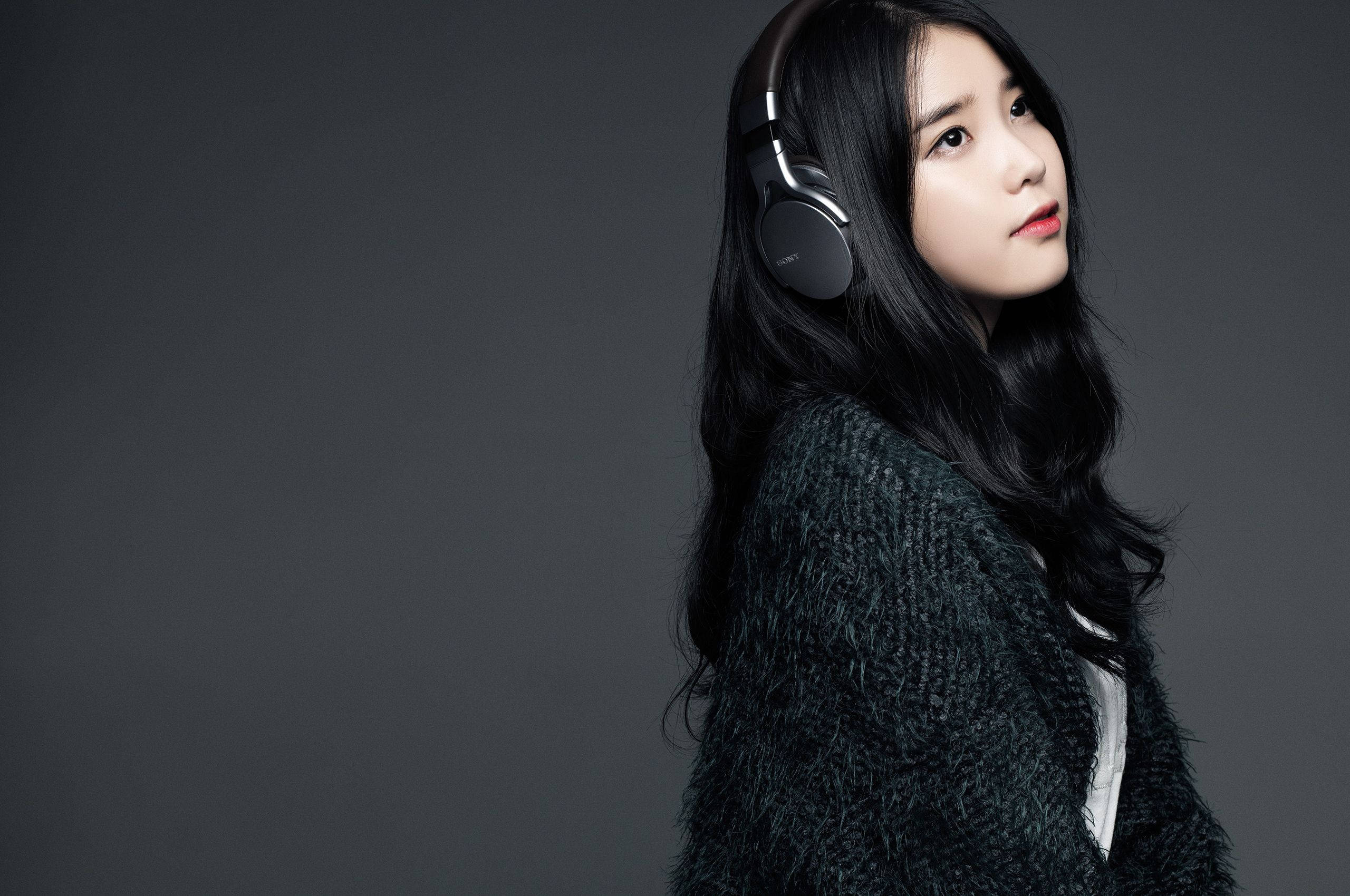 IU, over-ear headphones, textured dark sweater, 2K Desktop Wallpaper