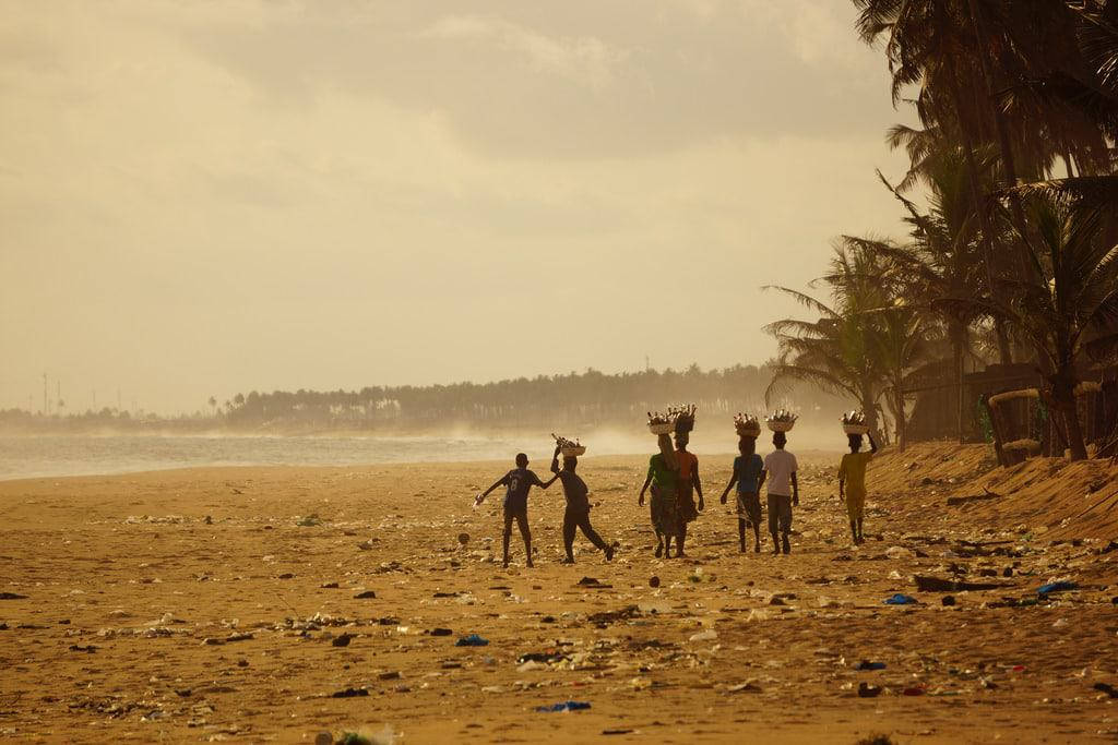 Ivory Coast, silhouetted figures, littered beach, SD Desktop Wallpaper