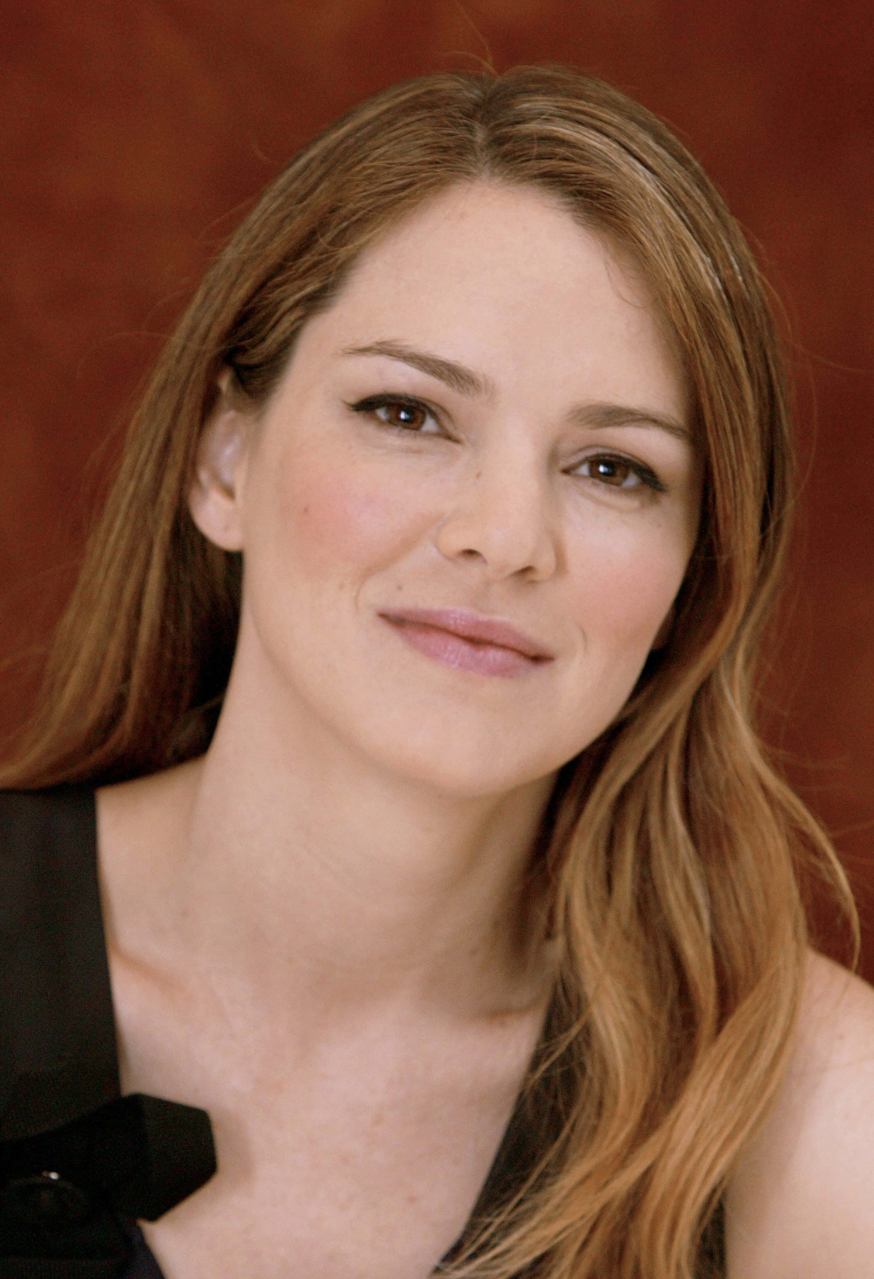 Jacinda Barrett, long brown hair, warm terracotta background, 4K Phone Wallpaper