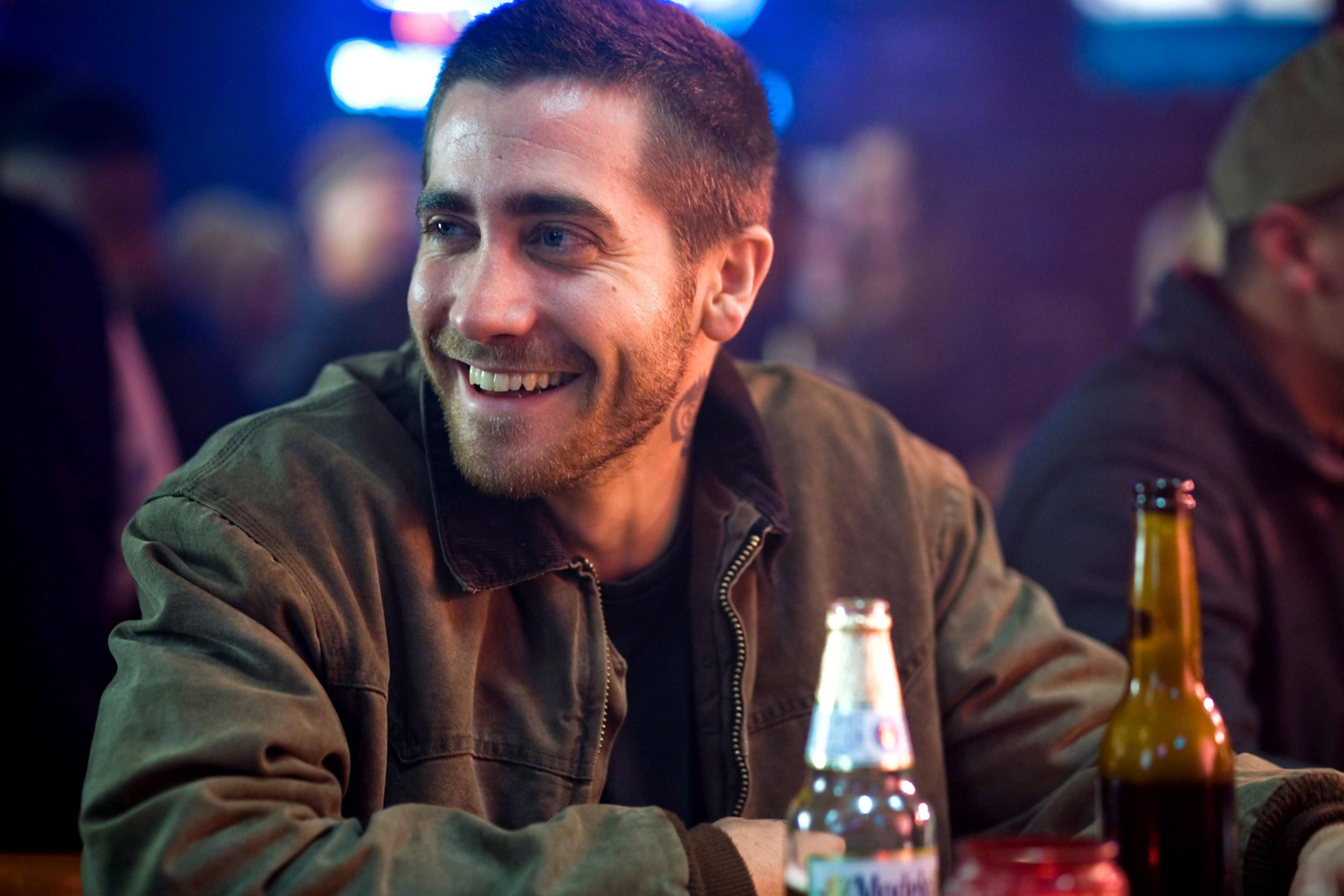 Jake Gyllenhaal, dimly lit bar, beer bottles, 2K Desktop Wallpaper