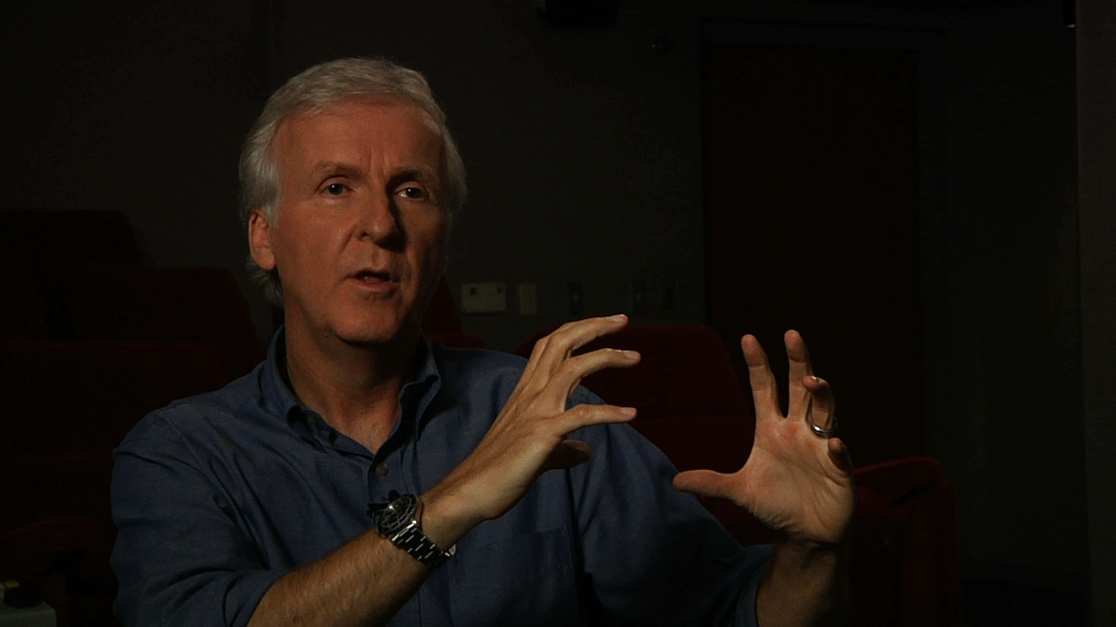 James Cameron, blue shirt, dimly lit theater, 4K Desktop Wallpaper
