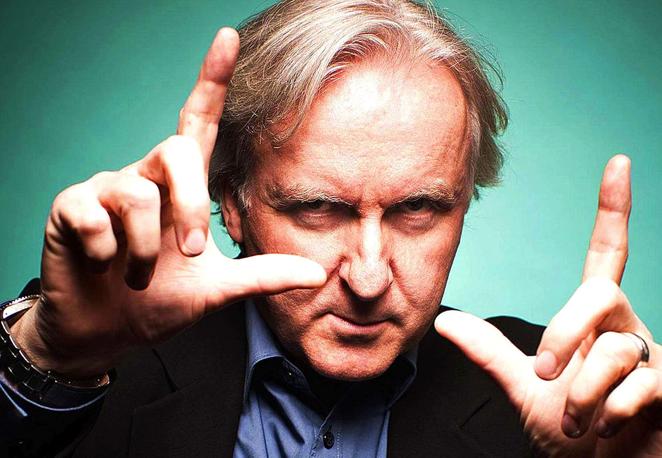 James Cameron, teal background, defiant hand gesture, 2K Desktop Wallpaper