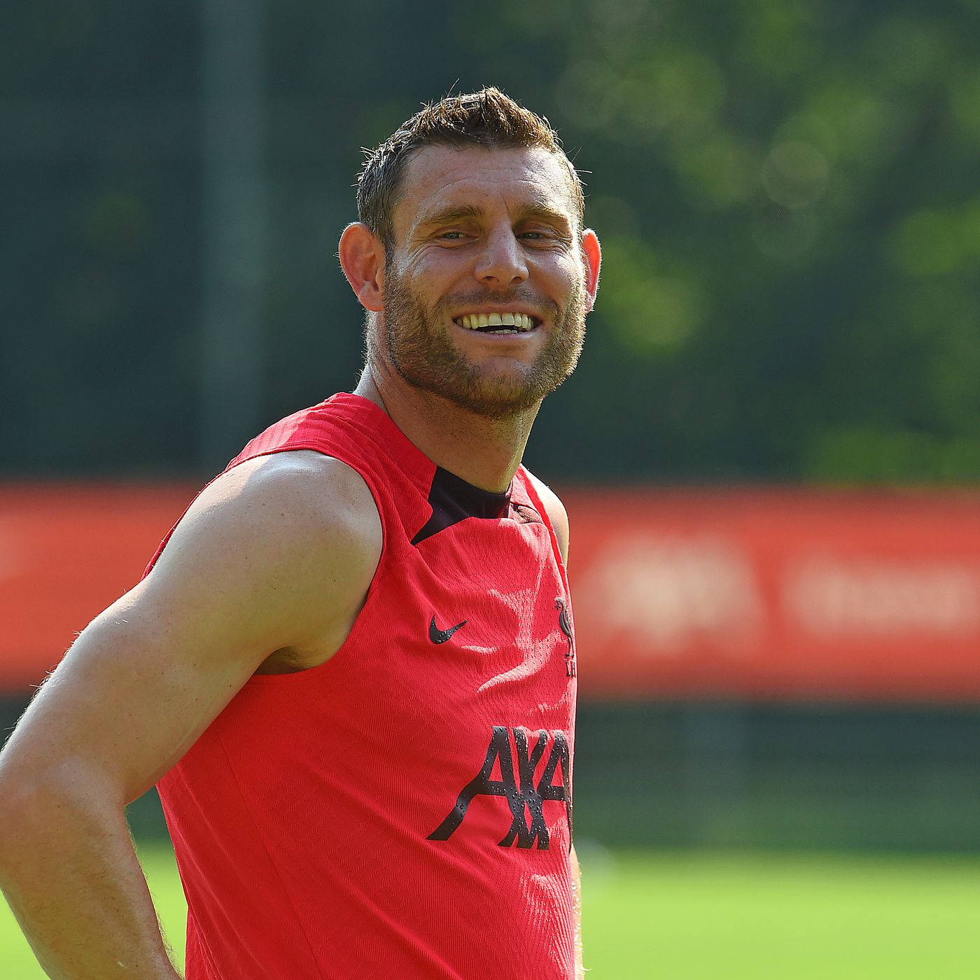 James Milner, red training jersey, sunlit grass field, HD Desktop Wallpaper