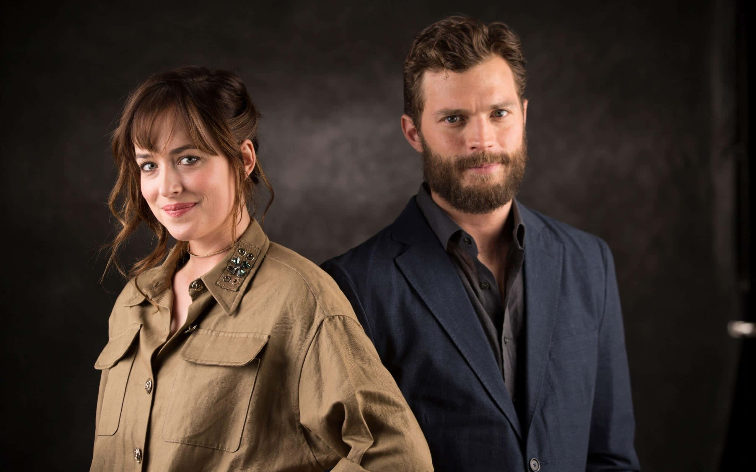 Jamie Dornan, studio lighting, dark textured backdrop, 2K Desktop Wallpaper
