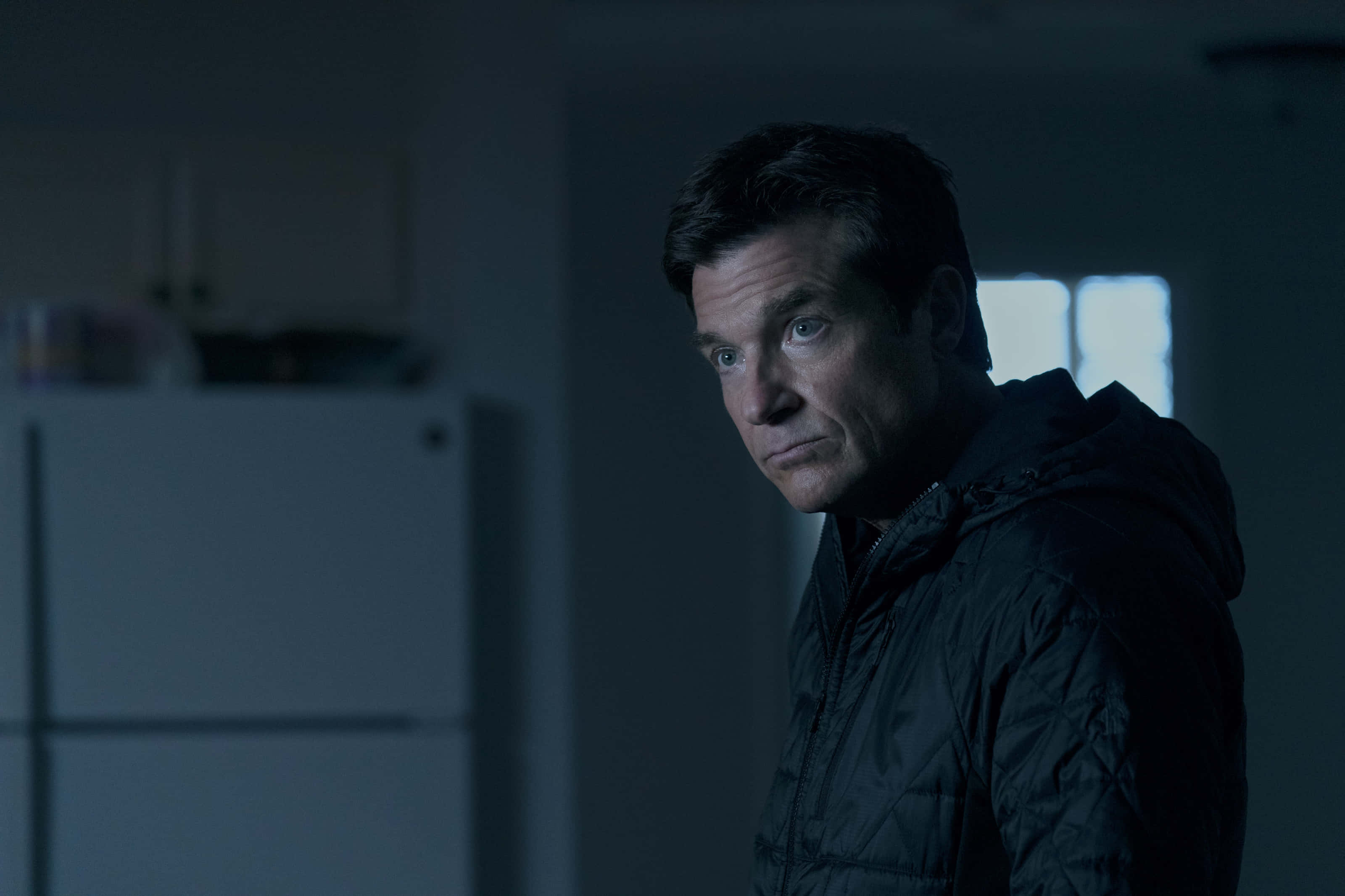 Jason Bateman, dark jacket, dimly lit kitchen, 2K Desktop Wallpaper