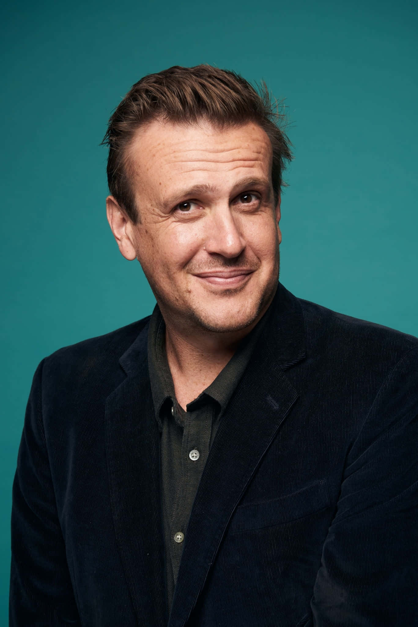 Jason Segel, dark corduroy blazer, solid teal studio background, Full HD Phone Wallpaper
