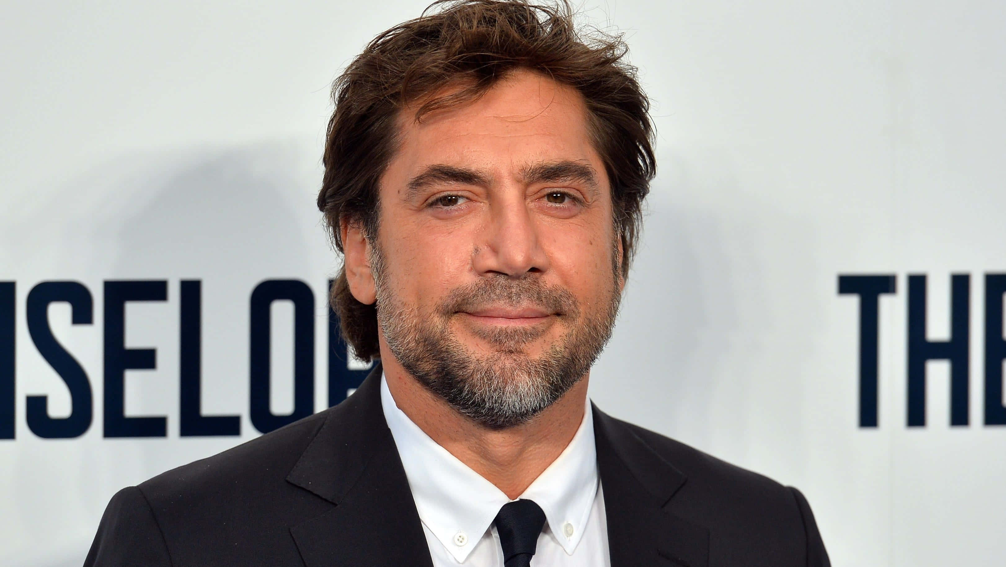 Javier Bardem, black suit and tie, white backdrop, 2K Desktop Wallpaper