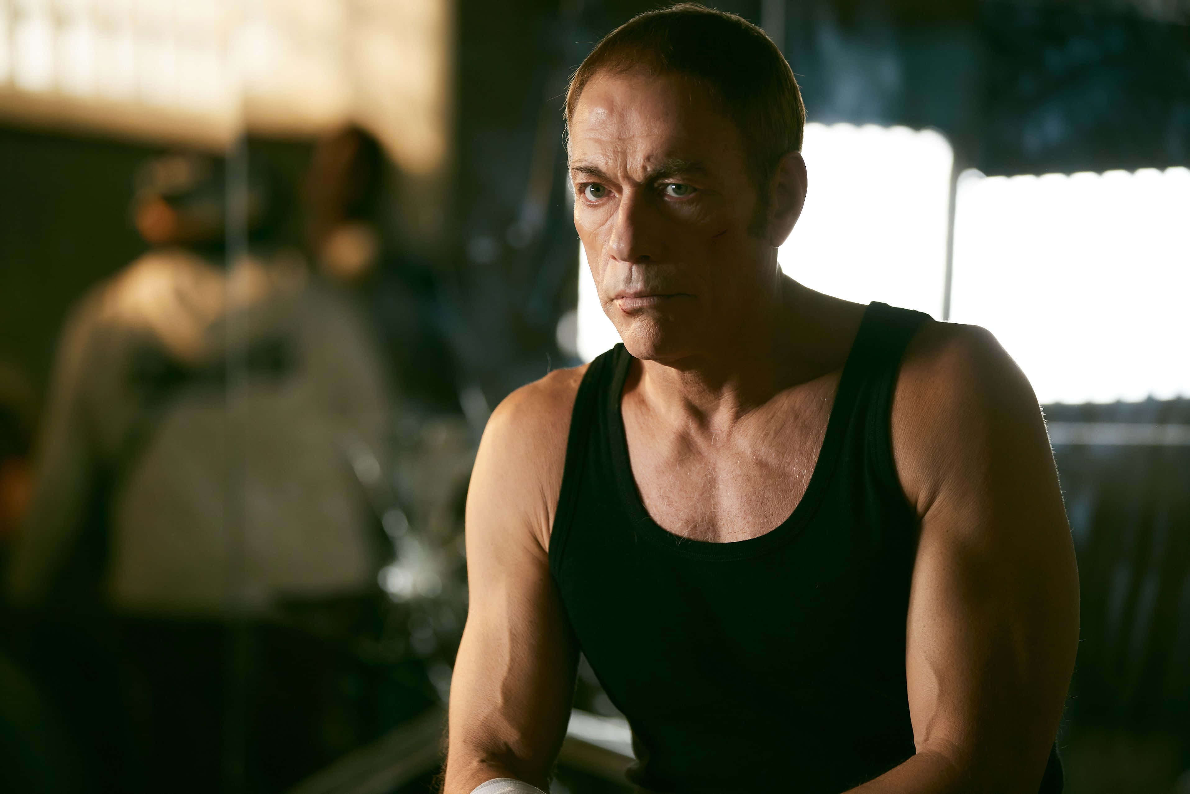 Jean Claude Van Damme, black tank top, dimly lit gym, 2K Desktop Wallpaper