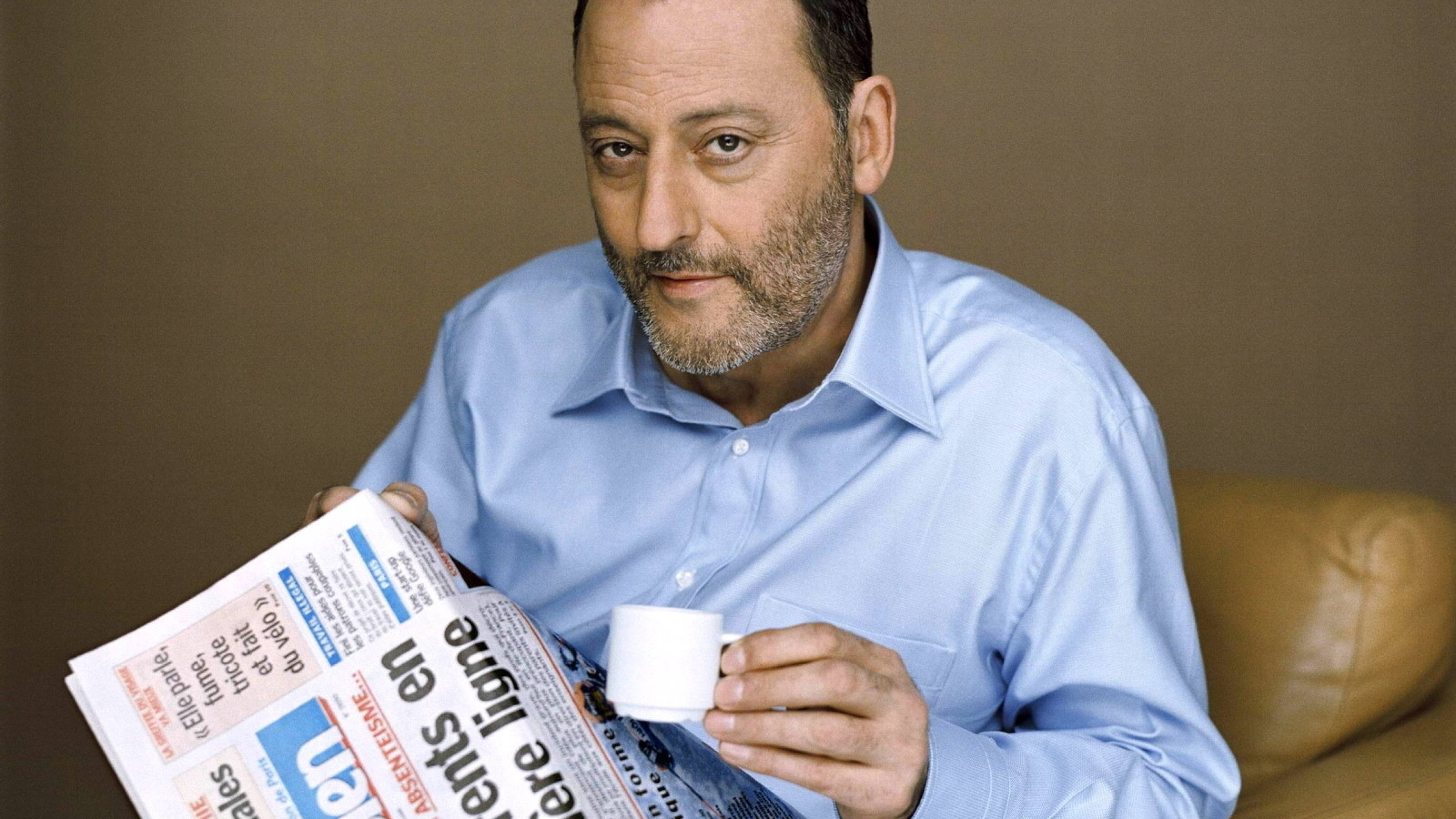 Jean Reno, light blue shirt, tan couch, 4K Desktop Wallpaper