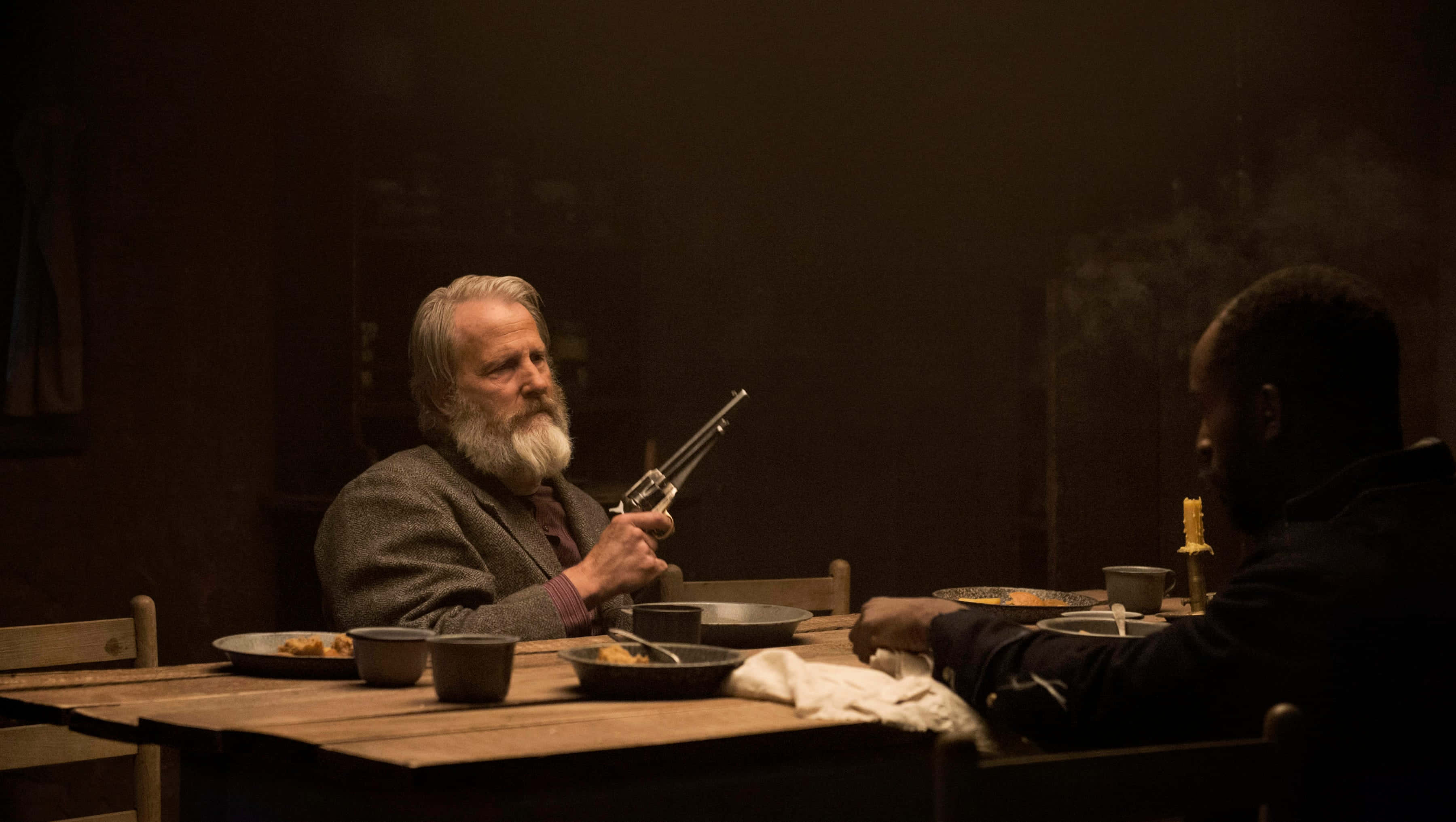 Jeff Daniels, wooden table, dimly lit room, 2K Desktop Wallpaper