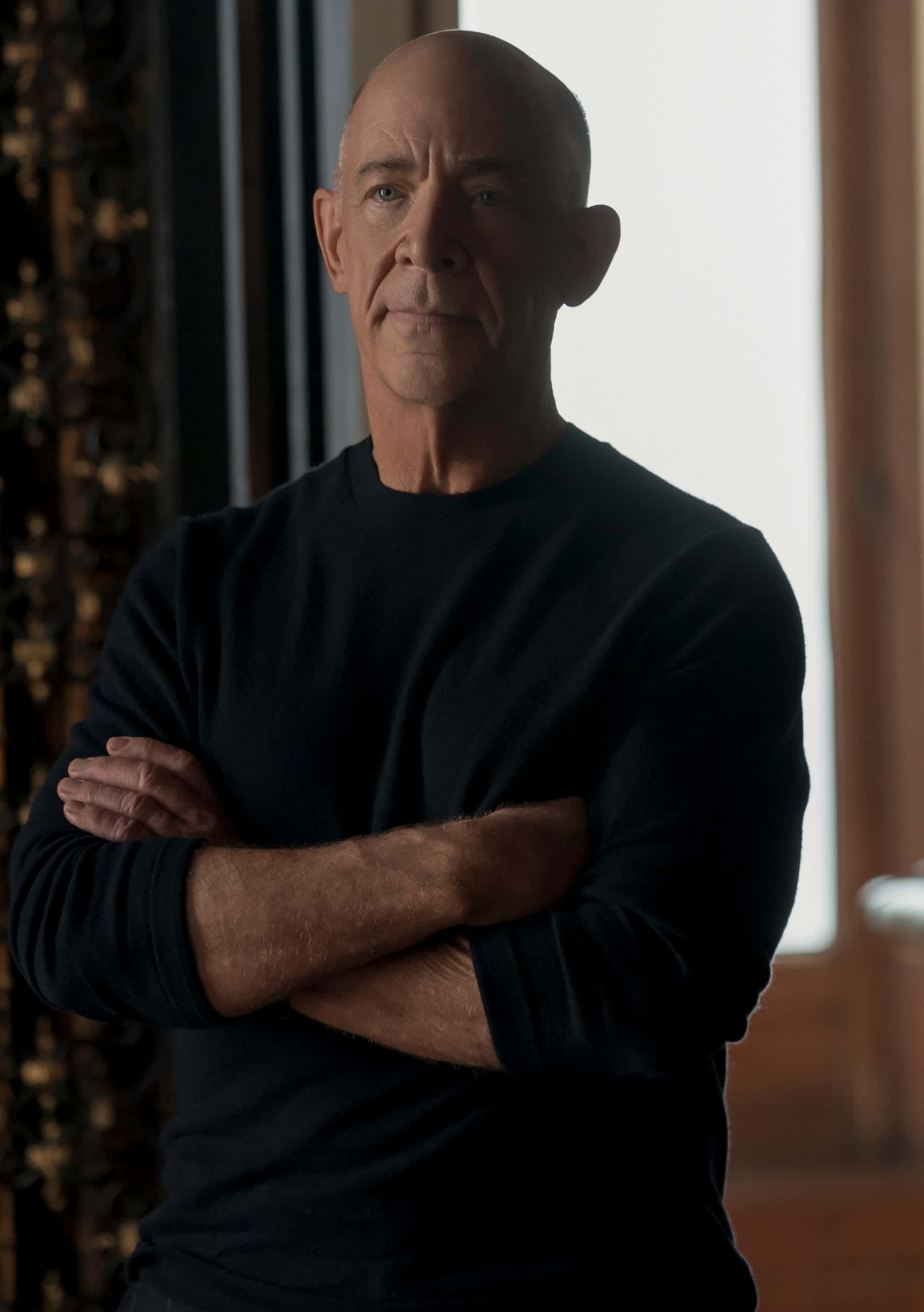J.K. Simmons, black sweater, softly lit room, 2K Phone Wallpaper