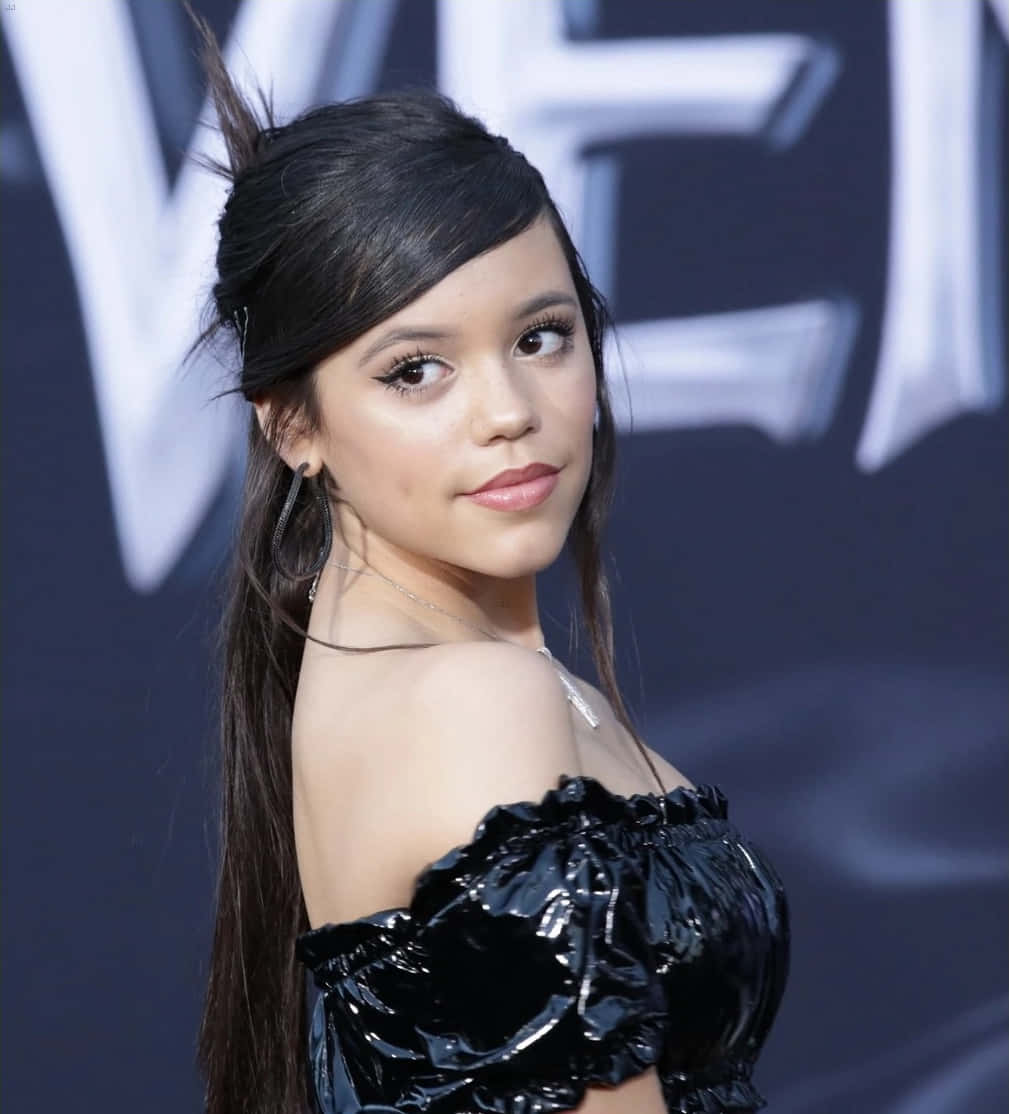 Jenna Ortega, shiny black off-shoulder top, dark backdrop, SD Phone Wallpaper