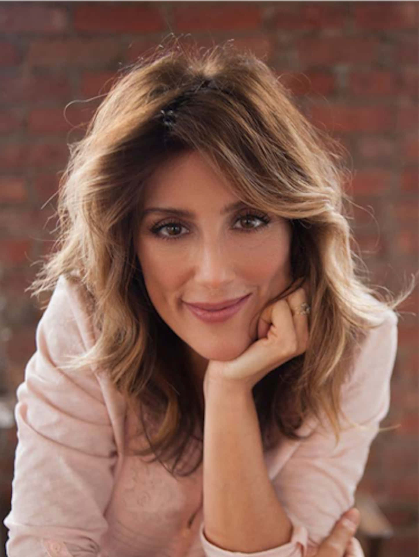 Jennifer Esposito, wavy blonde hair, red brick wall, Full HD Phone Wallpaper