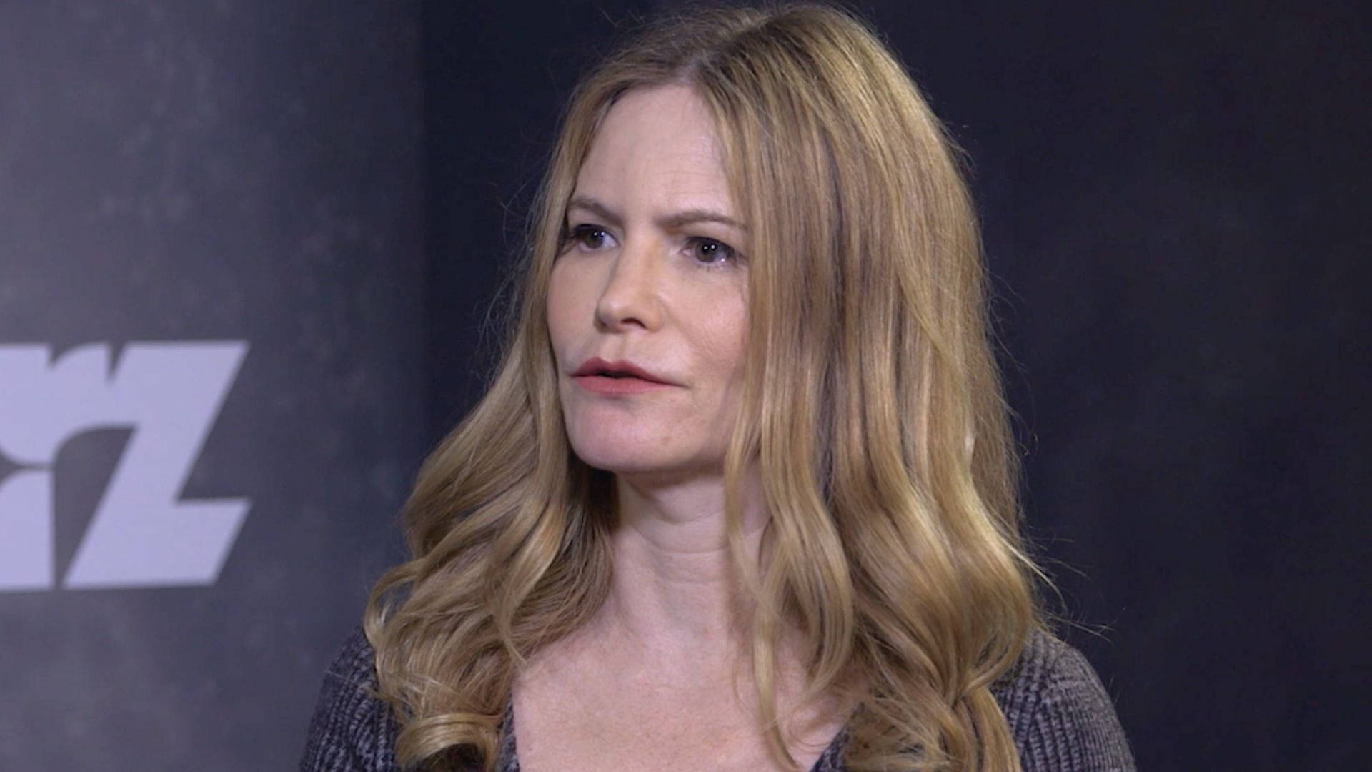 Jennifer Jason Leigh, long wavy blonde hair, dark backdrop, Full HD Desktop Wallpaper