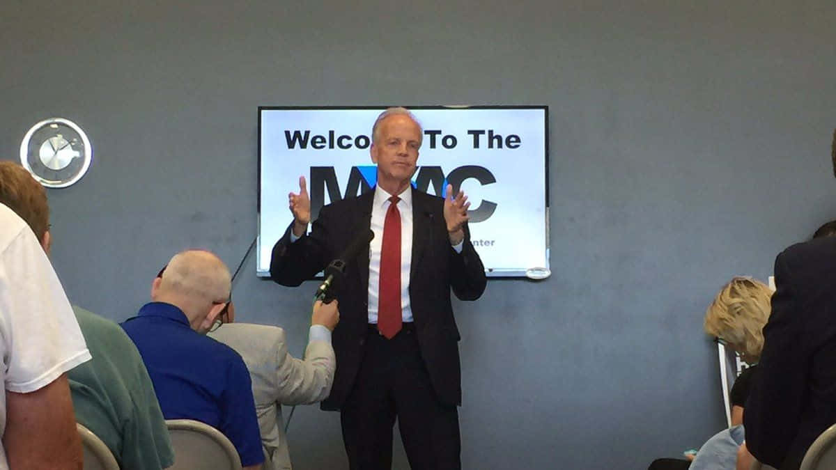 Jerry Moran, podium, screen displaying 'Welcome To The MAC', SD Desktop Wallpaper
