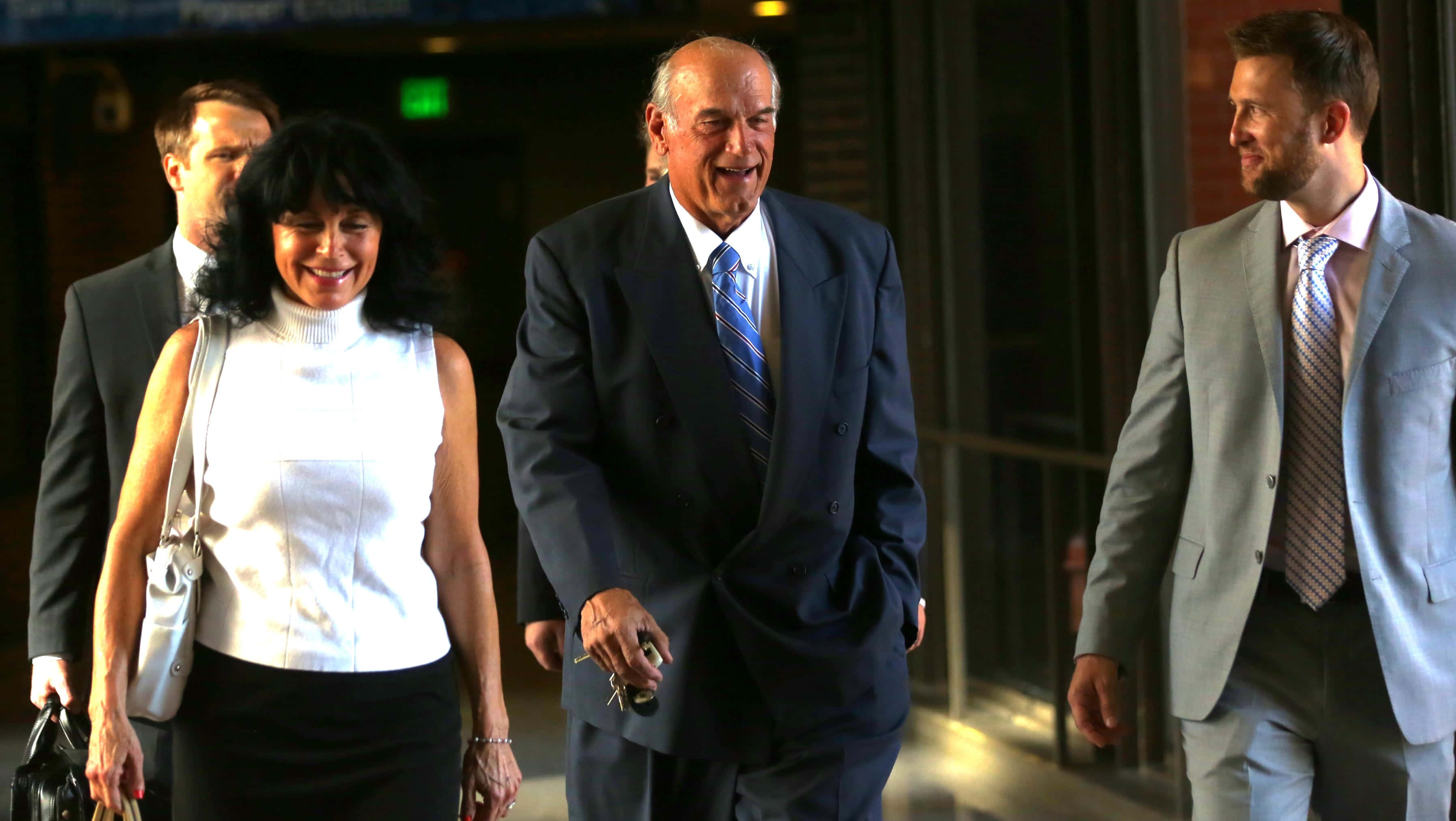 Jesse Ventura, dark suit, modern building entrance, 2K Desktop Wallpaper