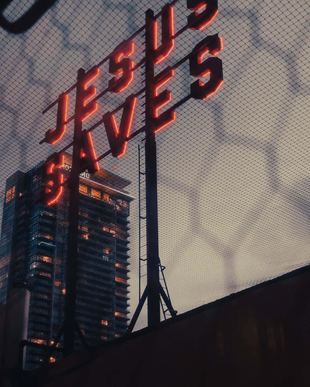 JESUS SAVES, glowing red neon sign, twilight city skyline, SD Phone Wallpaper