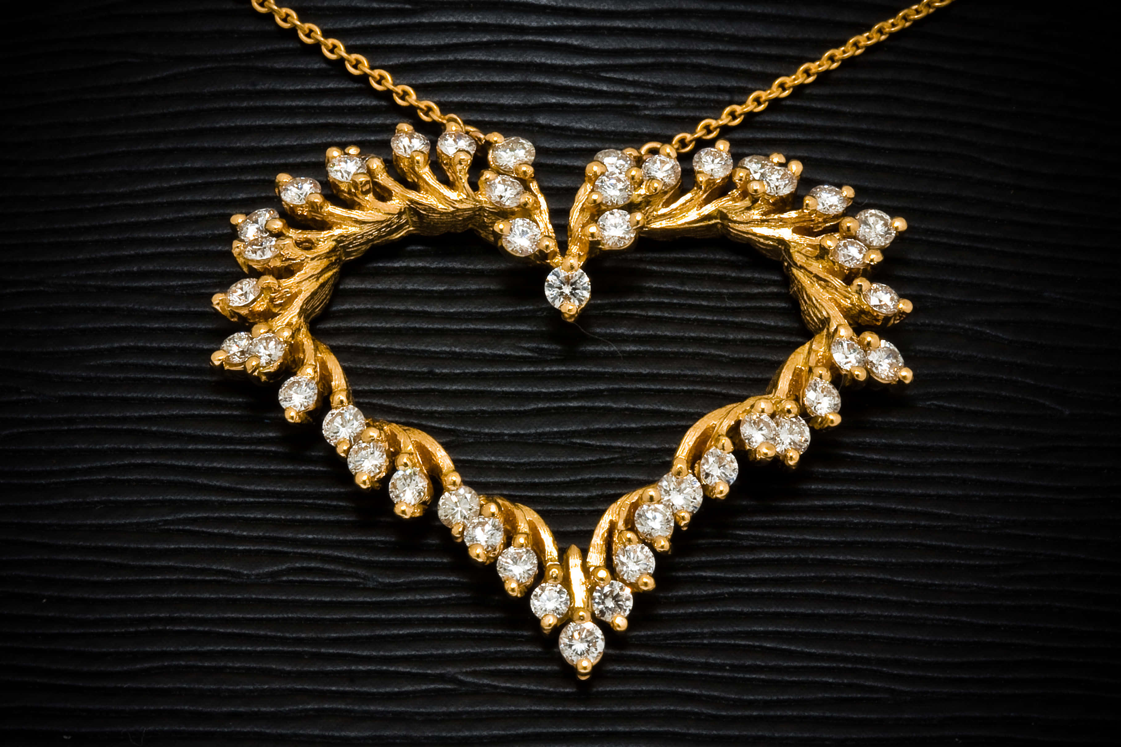 golden heart-shaped necklace, sparkling diamonds, textured black surface, 2K Desktop Wallpaper