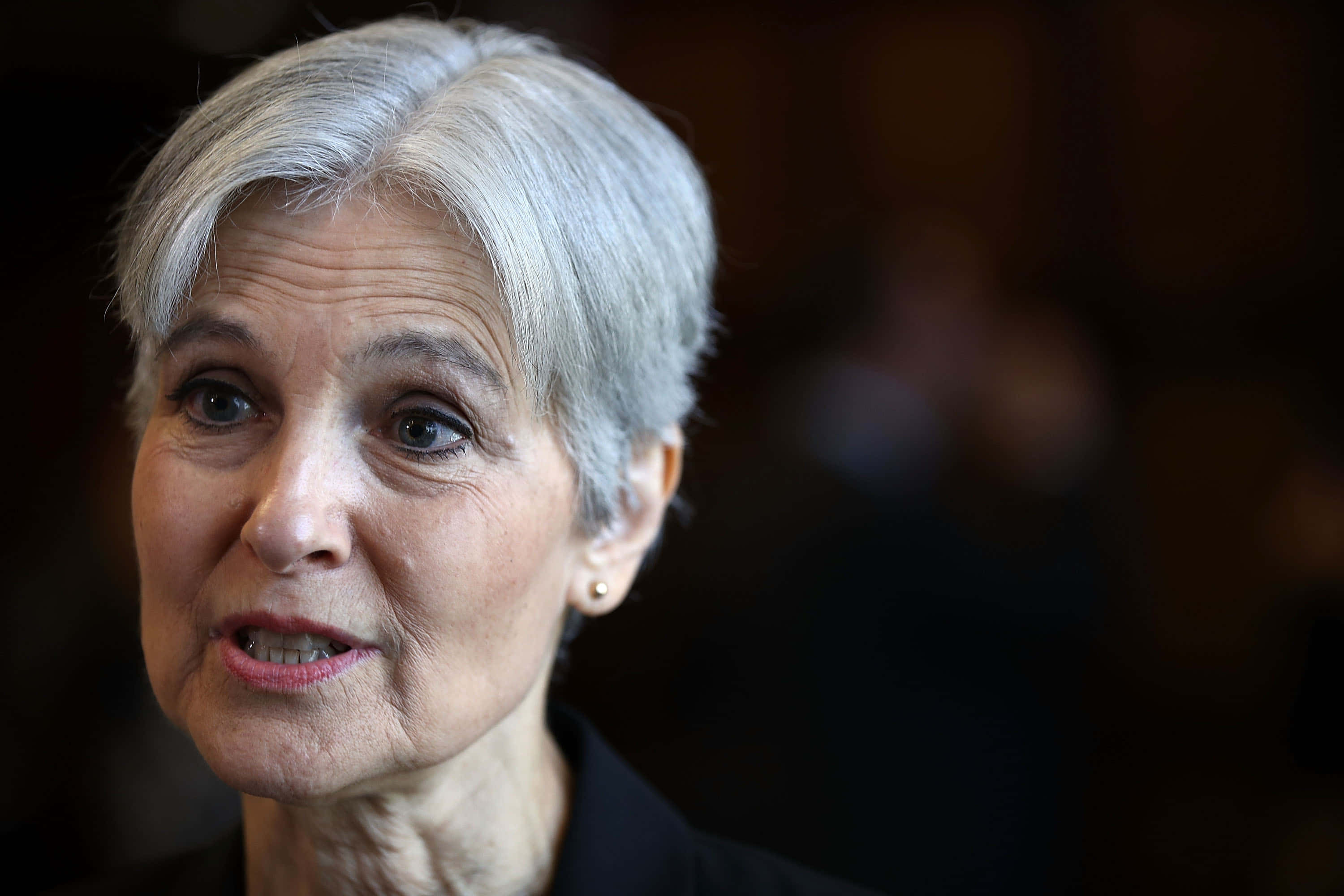 Jill Stein, short silver hair, serious expression, 2K Desktop Wallpaper