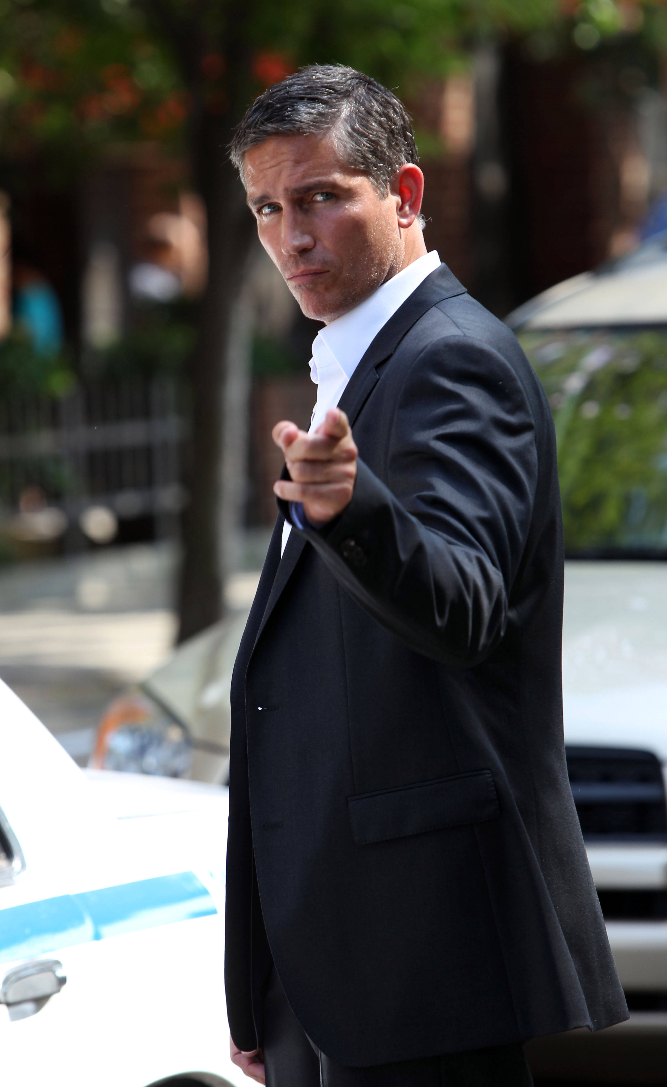 Jim Caviezel, dark suit, sunlit city street, 4K Phone Wallpaper