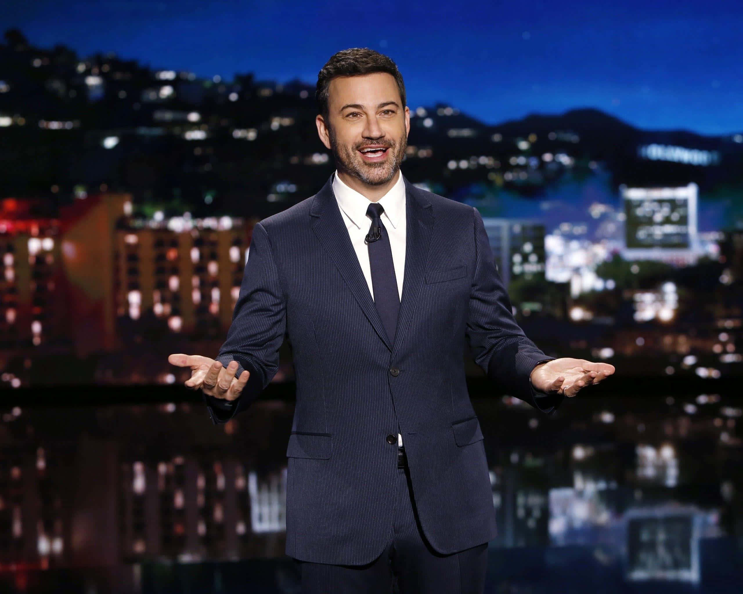 Jimmy Kimmel, dark pinstripe suit, nighttime cityscape, 2K Desktop Wallpaper