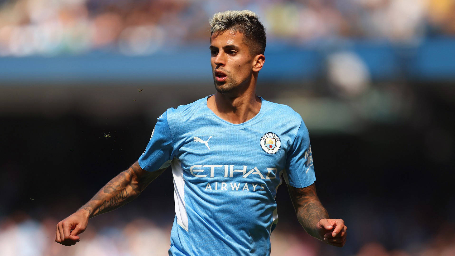 Joao Cancelo, light blue Manchester City jersey, sunlit stadium field, HD Desktop Wallpaper